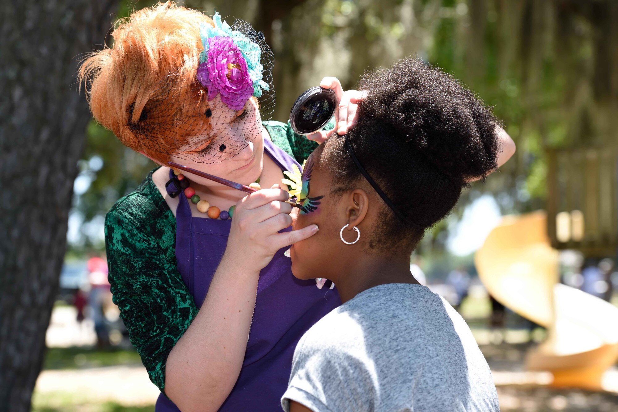 Heather Payne paints the face of a child of one of the 403rd Wing members during the 403rd Wing Airman and Family Day May 2, 2015, at Keesler Air Force Base, Mississippi. (U.S. Air Force Photo/Tech. Sgt. Ryan Labadens)