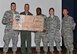 Colonel Derek France, 325th Fighter Wing commander, presents Tyndall’s first Dorm of the Quarter Award to Airman 1st Class Yaal Kand and Airman 1st Class Justin Powell, 325th Contracting Squadron contract specialists and Building 1054 dorm representatives, during the Quarterly Awards Ceremony April 29 at Horizons Community Center. Building 1054 received $1,000 toward moral and living condition improvements. (U.S. Air Force photo by Airman 1st Class Sergio Gamboa/Released)