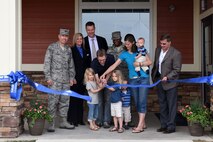 Malmstrom family members and Balfour Beatty Communities help cut the ribbon at the grand opening of a new community center May 5 at Malmstrom Air Force Base, Mont. The multi-purpose community center features an indoor pool, family fitness room, theater, conference room, kitchen, indoor and outdoor basketball courts, outdoor sporting field, and a playground. (U.S. Air Force photo/Chris Willis)