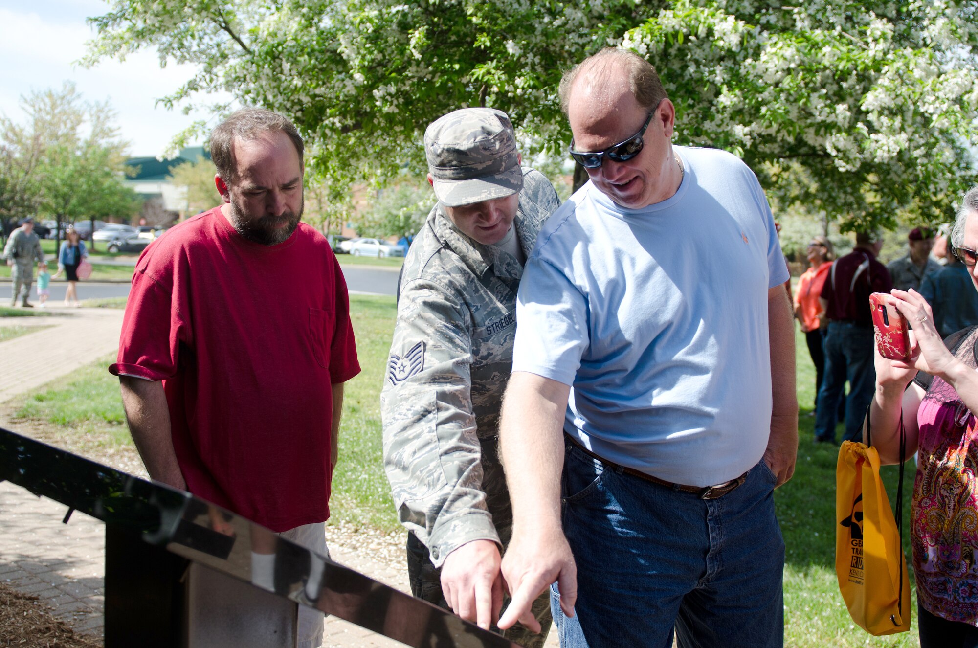 Retired Tech. Sgt. Earl J. Hartlage Jr. (right) finds his name on a plaque honoring retirees at the Kentucky Air National Guard Base in Louisville, Ky., April 18, 2015. The plaque was unveiled during a ceremony held for more than 50 members of the 123rd Airlift Wing who retired in 2014 after serving for 20 or more years. (U.S. Air National Guard photo by Senior Airman Joshua Horton)