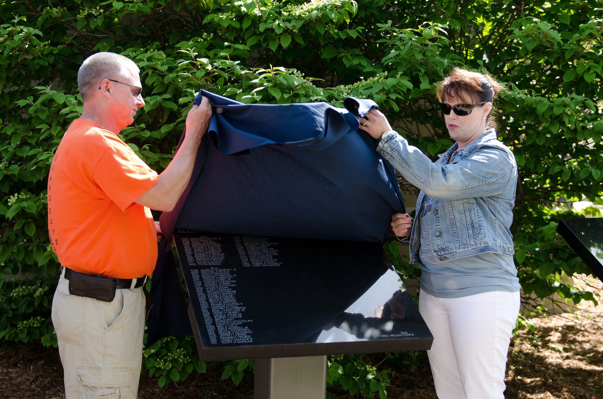 Retired Senior Master Sgt. Gary Dunlap and Retired Chief Master Sgt. Lori F. Zinsmeister unveil a plaque bearing the names of more than 50 Airmen who retired from the 123rd Airlift Wing last year during a ceremony at the Kentucky Air National Guard Base in Louisville, Ky., April 18, 2015.  The annual unveiling celebrates Airmen who served for 20 or more years. (U.S. Air National Guard photo by Senior Airman Joshua Horton)