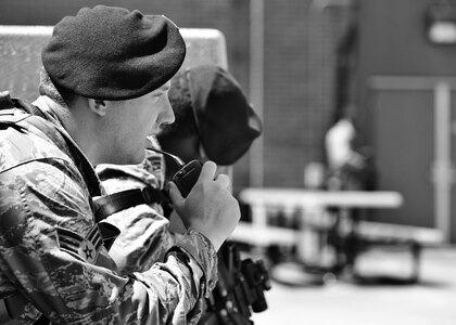 U.S. Air Force Senior Airman Kip Vaughan, 633rd Security Forces Squadron response force leader, communicates with other SFS members via radio during an exercise at Langley Air Force Base, Va., May 5, 2015. With an increased number of Security Forces members patrolling, less manning will be allocated to each gate, which means gate closures may occur during their least busy hours. (U.S. Air Force photo illustration by Airman 1st Class Devin S. Michaels/Released)