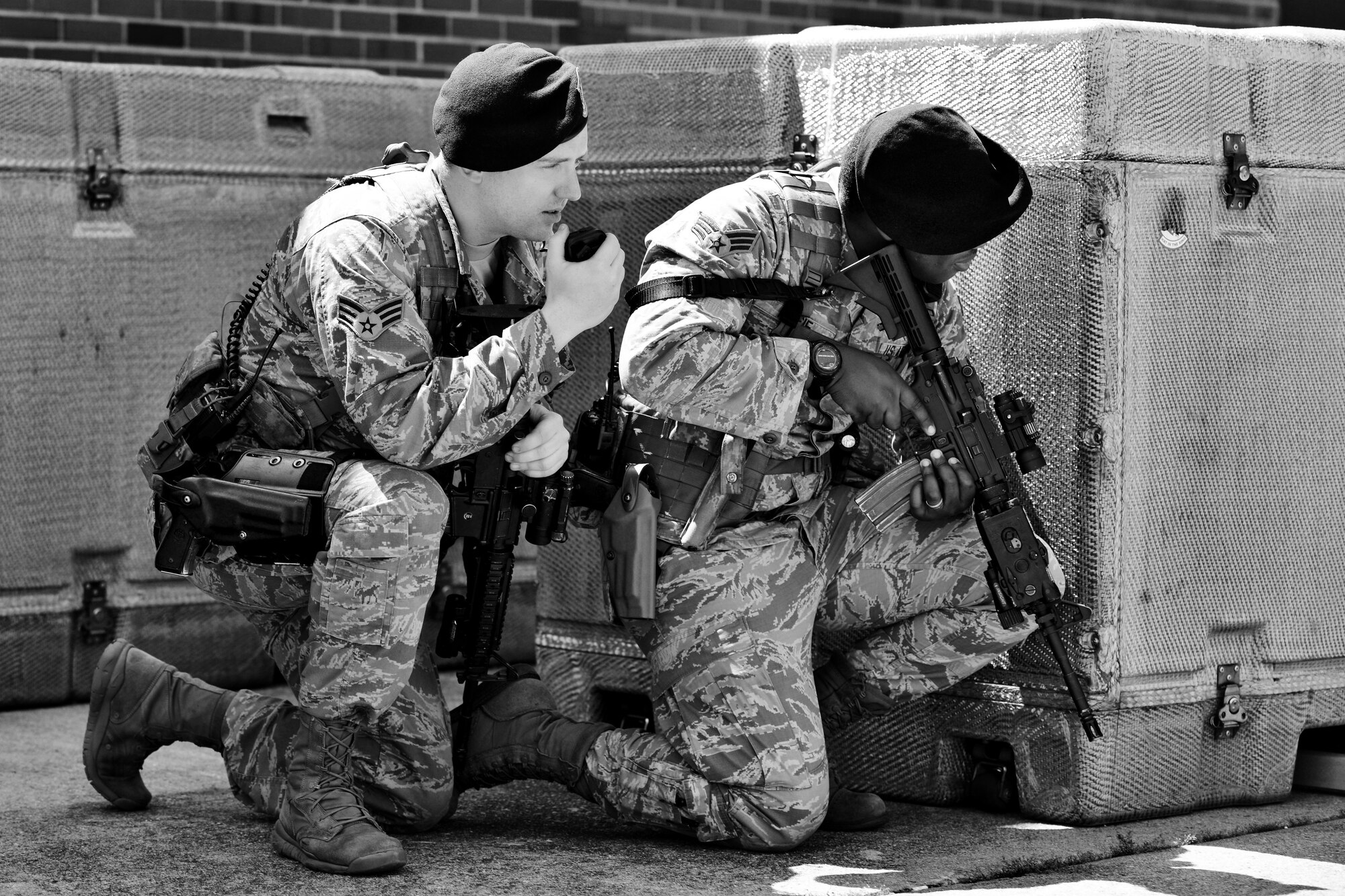 U.S. Air Force Senior Airmen Kip Vaughan and Quatari Moodie, 633rd Security Forces Squadron response force leaders, take cover during an exercise at Langley Air Force Base, Va., May 5, 2015. Patrolling Security Forces members are tasked with building checks, traffic monitoring, frequent perimeter checks and reporting observed safety violations. (U.S. Air Force photo illustration by Airman 1st Class Devin S. Michaels/Released)
