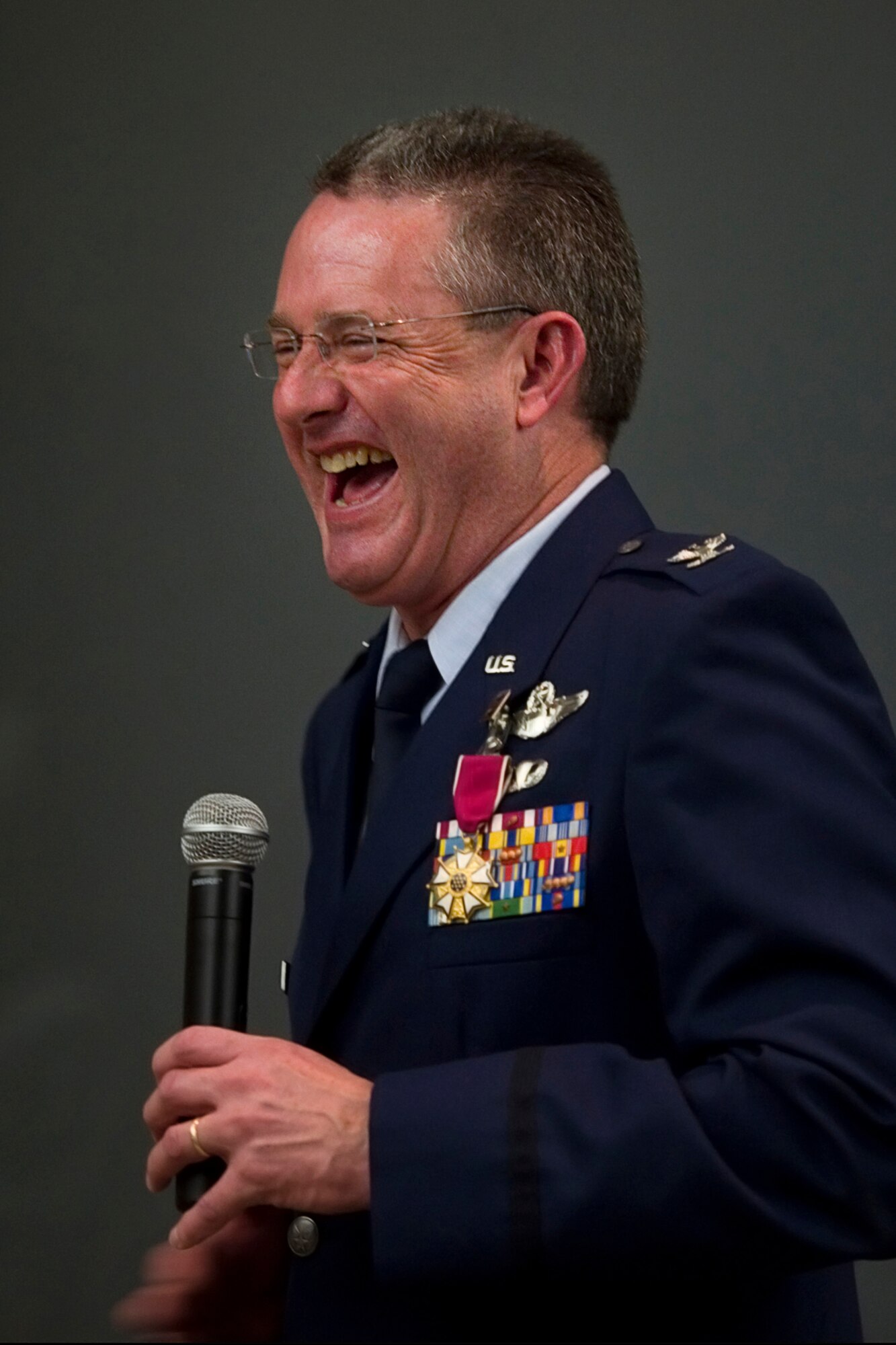 Col. Bryan Reinhart, 434th Air Refueling Wing vice commander, speaks to friends and family, enjoys a laugh while speaking during his retirement ceremony at Grissom Air Reserve Base, Ind., April 11, 2015. During the ceremony Reinhart was awarded the Legion of Merit in addition to his retirement certificate after more than 34 years of military service. (U.S. Air Force photo/Tech. Sgt. Benjamin Mota)