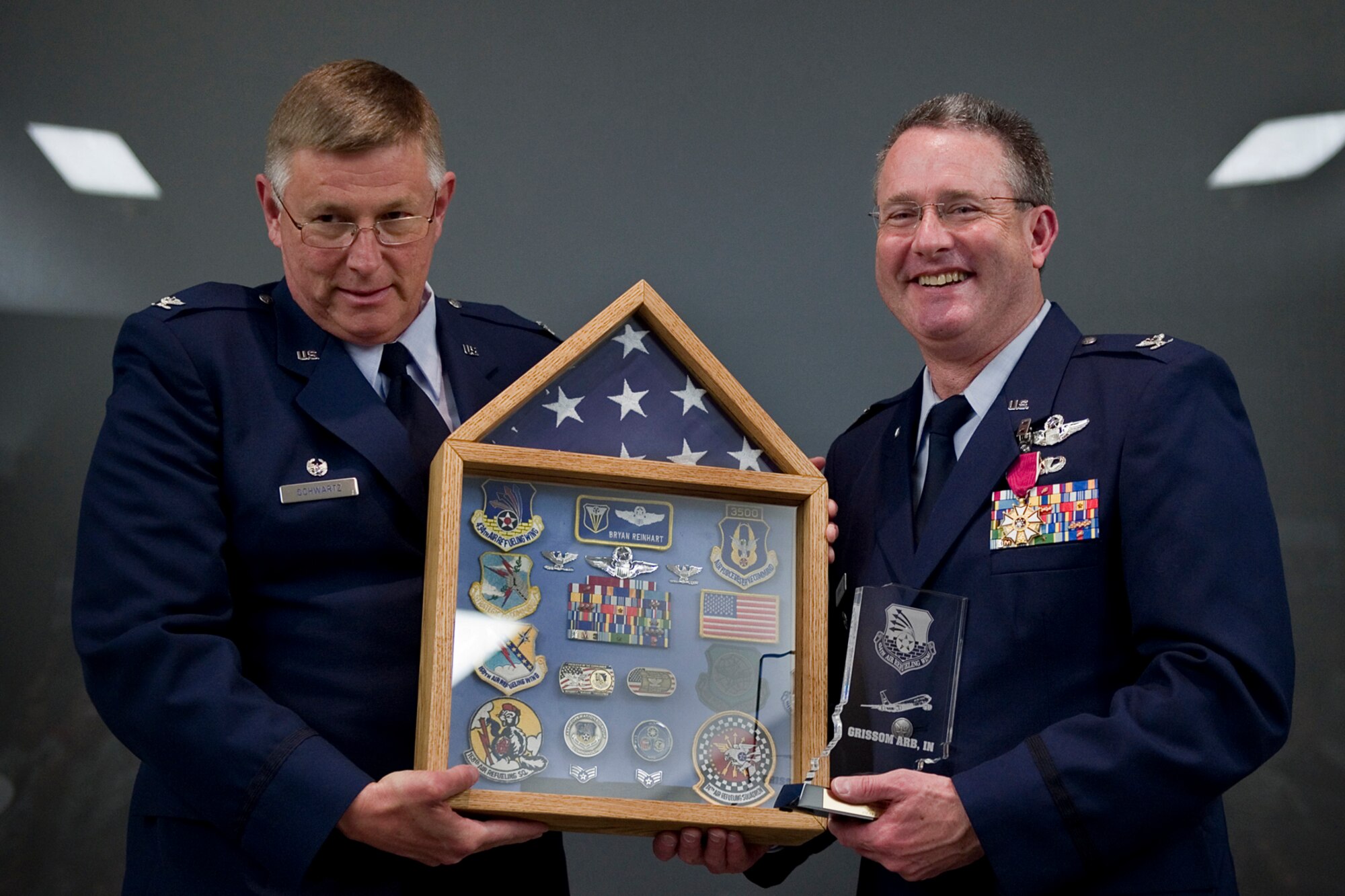 Col. Bryan Reinhart, 434th Air Refueling Wing vice commander, poses for a photo with Col. Douglas Schwartz, 434th Air Refueling Wing commander, after receiving a shadow box as a gift during his retirement ceremony at Grissom Air Reserve Base, Ind., April 11, 2015. Reinhart is a command pilot with more than 3,500 flying hours and a commercial pilot in his civilian capacity. (U.S. Air Force photo/Tech. Sgt. Benjamin Mota)