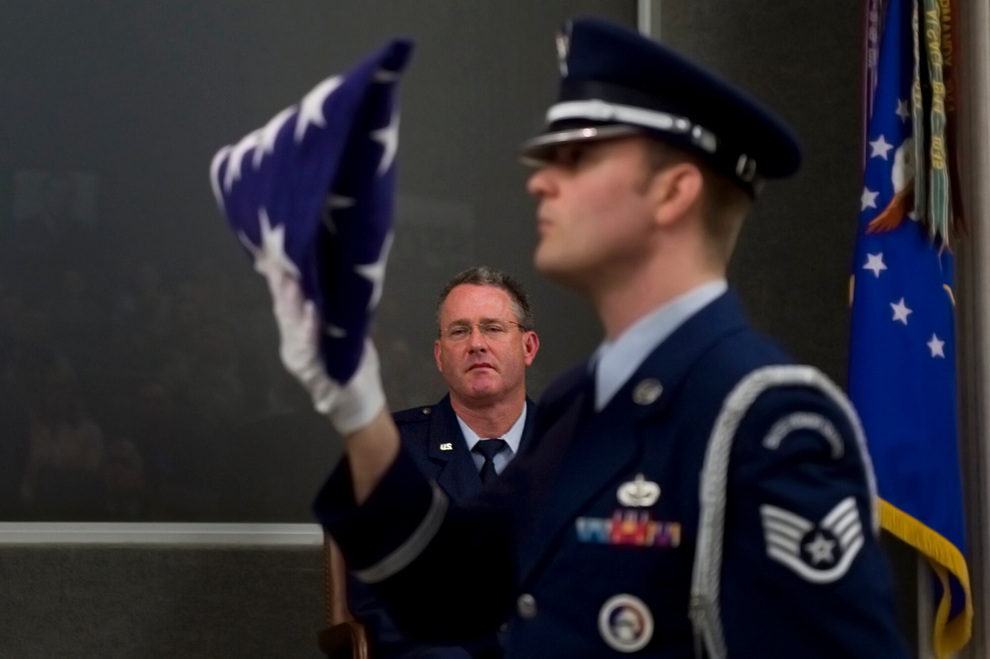 Col. Bryan Reinhart, 434th Air Refueling Wing vice commander, watches as Tech. Sgt. Ben Durr, 434th Security Forces Squadron security response team member, completes a full dress of an American flag during Reinhart's retirement ceremony at Grissom Air Reserve Base, Ind., April 11. Reinhart officially retired from the Air Force Reserve April 30, with over 34 years of service. (U.S. Air Force photo/Tech. Sgt. Benjamin Mota)