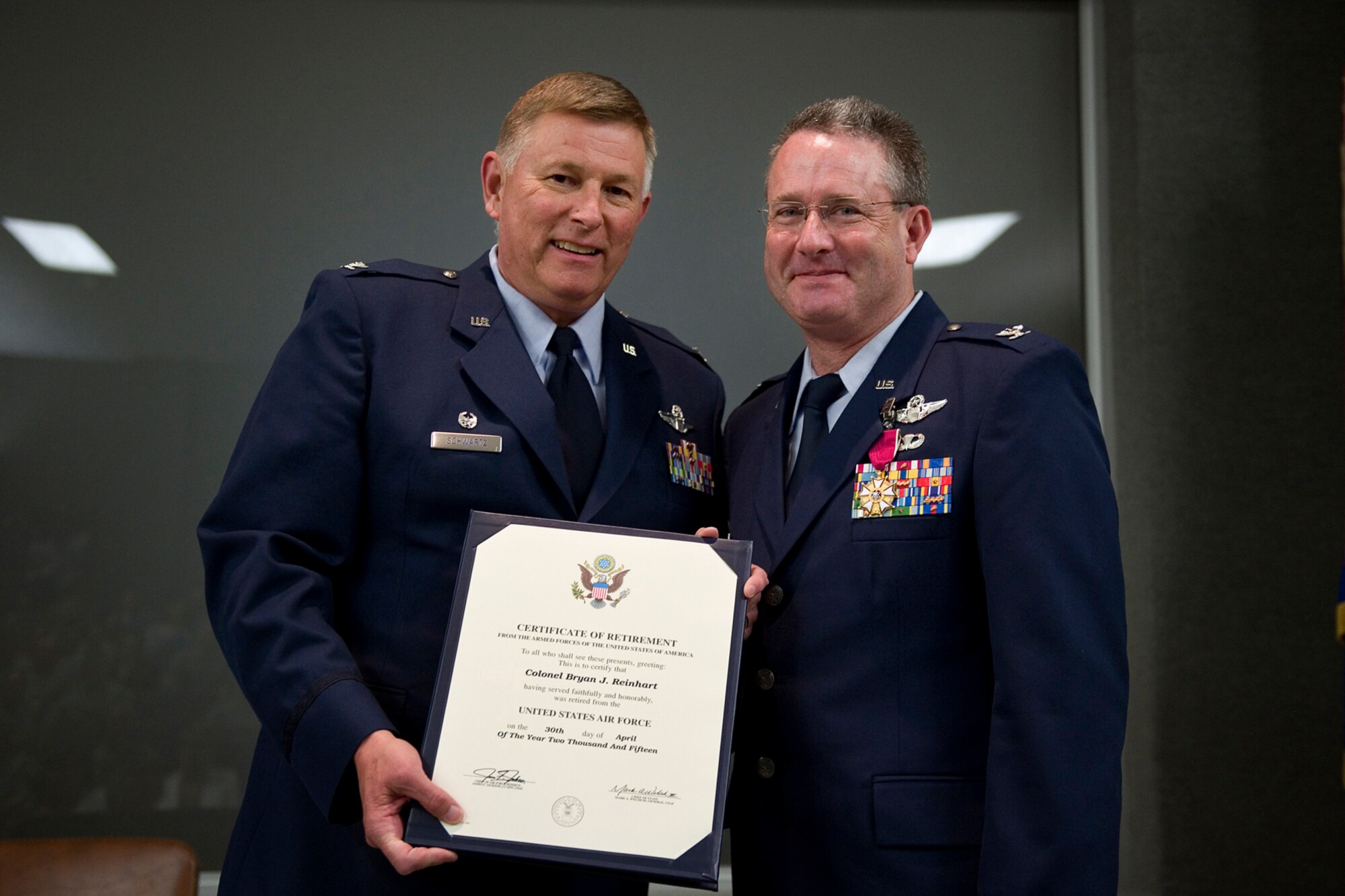 Col. Bryan Reinhart, 434th Air Refueling Wing vice commander, poses for a photo after receiving his certificate of retirement from Col. Douglas Schwartz, 434th Air Refueling Wing commander, during his retirement ceremony at Grissom Air Reserve Base, Ind., April 11, 2015. Reinhart officially retired from the Air Force Reserve April 30, with over 34 years of service. (U.S. Air Force photo/Tech. Sgt. Benjamin Mota)