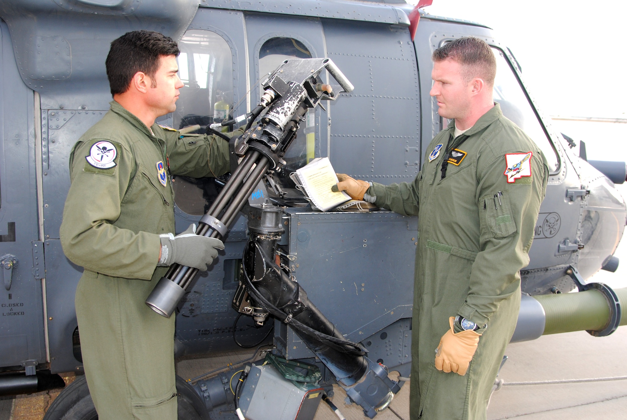 Staff Sgt. Robert Blacknall (right), 512th Special Operations Squadron, and Tech Sgt. Lane Miller, 150th Special Operations Wing, New Mexico Air National Guard, conduct a pre-flight inspection on the right gun on an HH-60 Pave Hawk helicopter at Kirtland recently. While Blacknall is regular Air Force and Miller is an active guard member, the two work side by side as Instructor Special Mission Aviators in the 512th under the total force integration between the 58th and 150th SOWs. (Photo by Jim Fisher)
