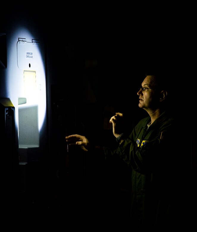 Chief Master Sgt. Jeffrey Wilson, 437th Operations Group superintendent, inspects the insides of a C-17 Globemaster III with a flashlight May 5, 2015, on the flightline at Robins Air Force Base, Ga. A Joint Base Charleston, S.C., aircrew and Boeing Team flew this ceremonial flight commemorating the 3,000,000 flying hour milestone for the entire C-17 fleet. (U.S. Air Force photo/Airman 1st Class Clayton Cupit)