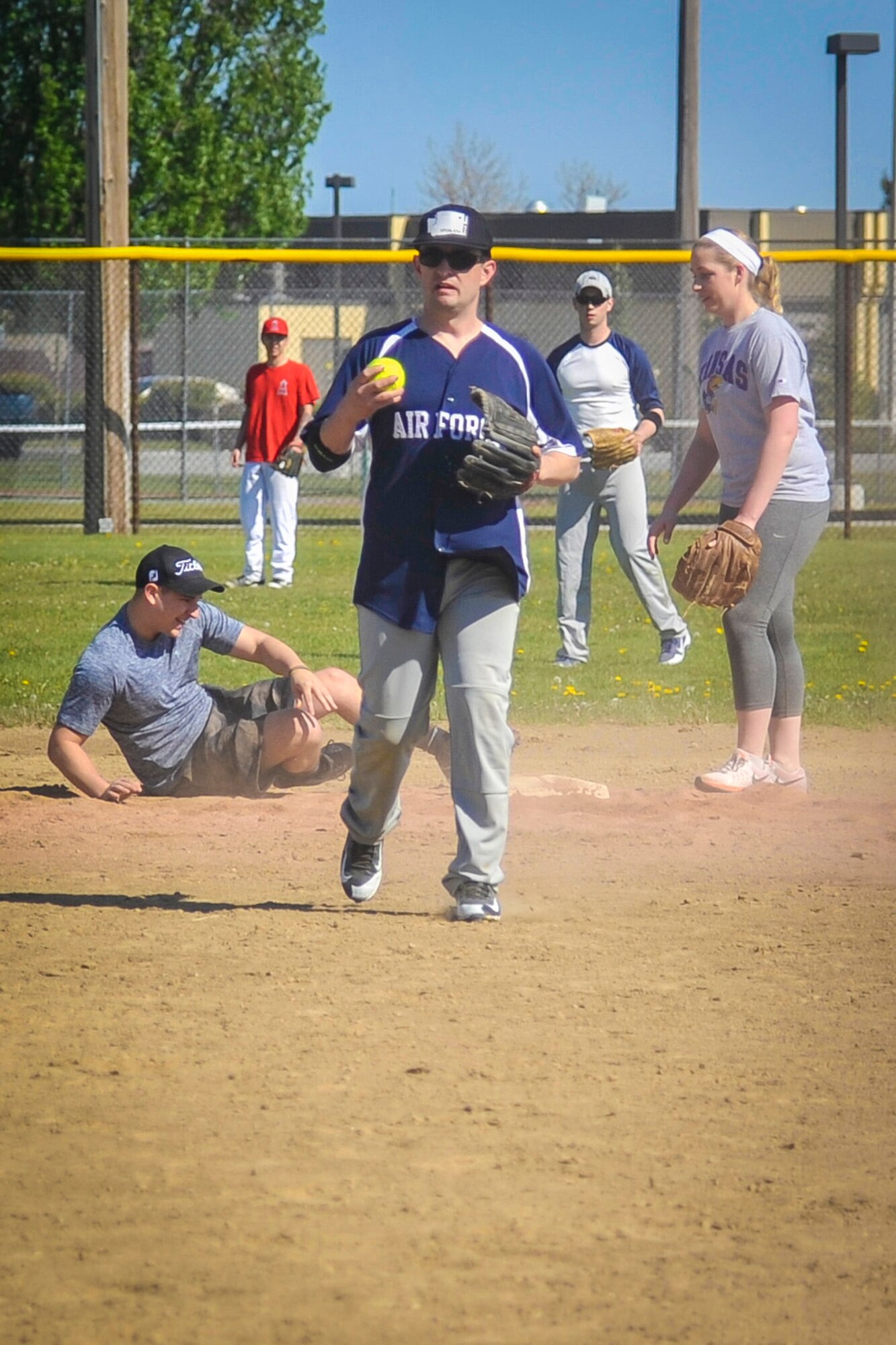Members from the 92nd Aircraft Maintenance Squadron team tag a player diving for second base May 2, 2015, at the softball fields on Fairchild Air Force Base, Wash. During the tournament each team played roughly three games leading to the 92nd AMXS taking the tournament with a crushing 18-8 win over the 336th Training Group Airmen from the U.S. Air Force Survival School. (U.S. Air Force photo/Airman 1st Class Taylor Bourgeous)