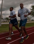 Senior Airman William Noundou, air transportation specialist for the 70th Aerial Port Squadron and Senior Master Sgt. Gerard Matos, superintendent of critical sections for the 70th APS, participate in the Port Dawg 5k on the track behind the Sam Johnson Fitness Center at Homestead Reserve Base, Fla., May 2. Members of the 70th APS participated in the Port Dawg 5K in honor of fallen Aerial Porters from around the world and build unit camaraderie. (U.S. Air Force photo by Senior Airman Aja Heiden)