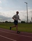 Chief Master Sgt. Frederick Becking, operations chief for the 70th Aerial Port Squadron, finishes a lap around the track located behind the Sam Johnson Fitness Center at Homestead Reserve Base, Fla., May 2. The Port Dawg 5K goes beyond squadrons to unify Air Force Aerial Porters and honor comrades who have lost their lives. (U.S. Air Force photo by Senior Airman Aja Heiden) 