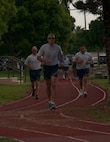 Tech. Sgt. Rick Hutson, aerial port trainer, Maj. Kenneth Scott, operations officer and Chief Master Sgt. Frederick Becking, operations chief, from the 70th Aerial Port Squadron run on the track located behind the Sam Johnson Fitness Center at Homestead Reserve Base, Fla., May 2. They ran as part of the Port Dawg 5K which is a yearly event where Aerial Porters around the world gather to show their support for one another and honor their fallen comrades. (U.S. Air Force photo by Senior Airman Aja Heiden)
