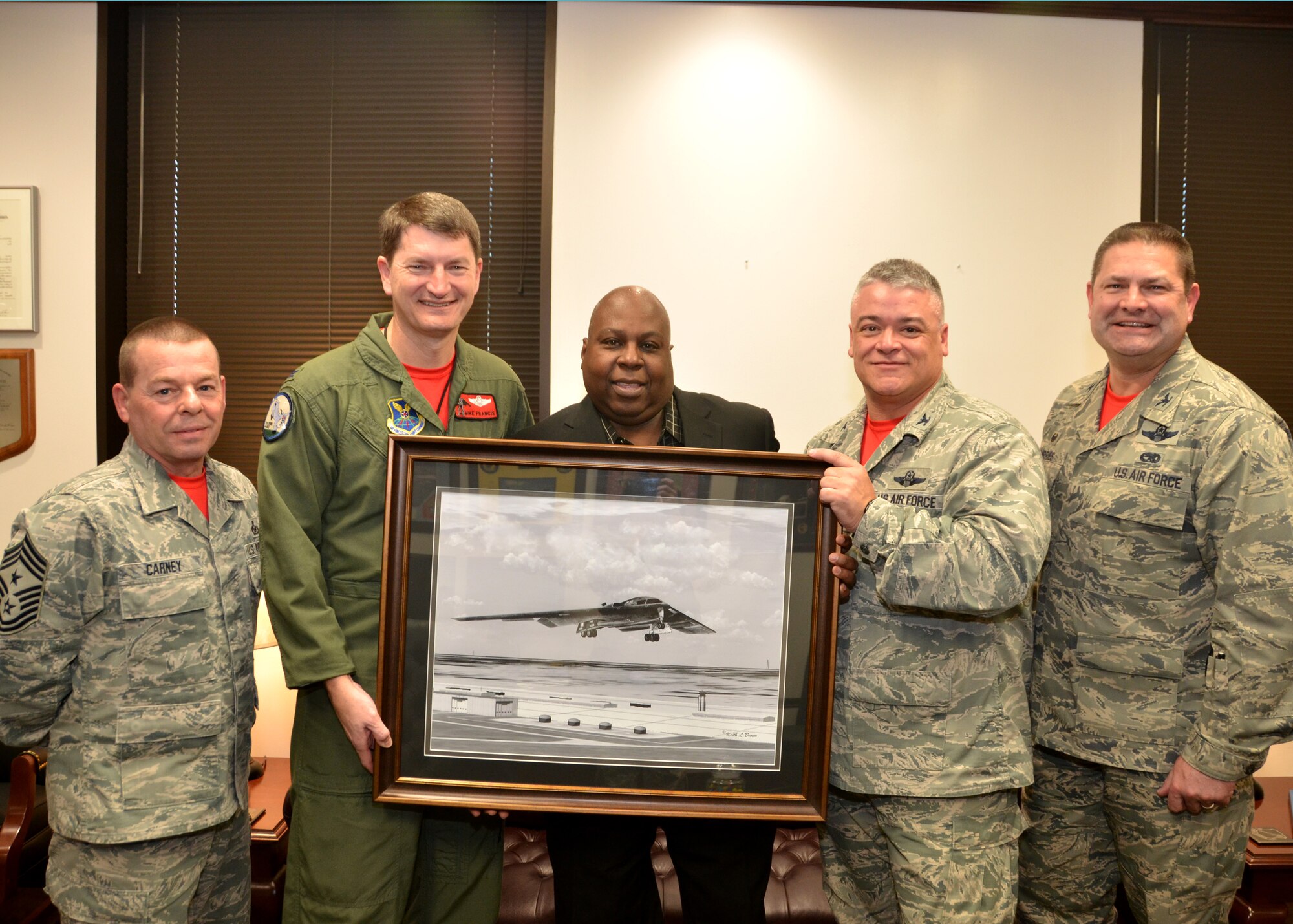 Retired Chief Master Sgt. Keith Brown, center, presents his original artwork to 131st Bomb Wing leadership, Feb. 8, 2015.  Brown designed the illustration of the B-2 “Spirit of Missouri” especially for the 131st Bomb Wing, to commemorate the dedication of the bomber to the Missouri Air National Guard.  Pictured from left to right: Chief Master Sgt. Paul Carney, 131st Bomb Wing command chief, Col. Michael Francis, 131st Bomb Wing commander, Brown, Col. Kenneth Eaves, 131st Bomb Wing vice commander, and Col. Michael Jurries, 131st Mission Support Group commander.  (U.S. Air National Guard photo by Tech. Sgt. Traci Payne)