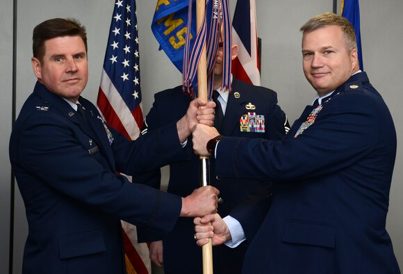 U.S. Air Force Lt. Col. Frank Livingston, right, 727th Air Mobility Squadron commander, passes the 727th AMS guidon to U.S. Air Force Col. Matthew Anderer, 721st Air Mobility Operations Group commander, Ramstein Air Base, Germany, during the 727th AMS change of command ceremony May 6, 2015, on RAF Mildenhall, England. The passing of the unit guidon during a change of command ceremony is a symbolic representation of passing authority to the incoming commander. (U.S. Air Force photo by Gina Randall/Released)