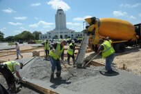 Members of the 502nd Civil Engineer Squadron from Joint Base San Antonio-Fort Sam Houston spread and add the finishing touches to the concrete for the JBSA-Randolph Washington Circle star April 15 during the landscaping phase of the star’s transformation. The star has shone at JBSA-Randolph since its Randolph Field beginnings. Aerial photographs show that the star was already a prominent feature while the administration building, which later became known as the Taj Mahal, was being constructed circa 1930.  (U.S. Air Force photo by Joel Martinez/Released)