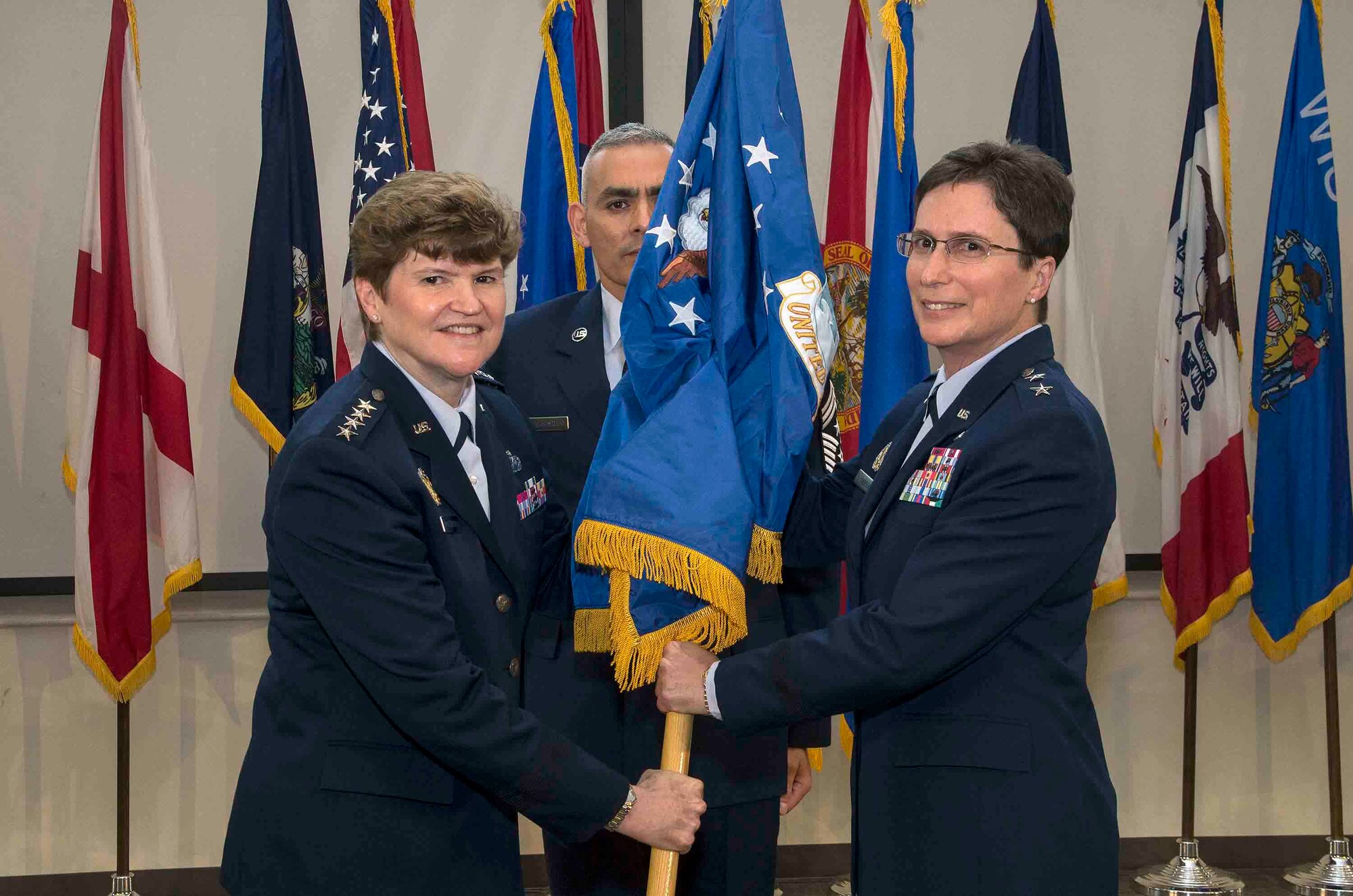 Gen. Janet C. Wolfenbarger, commander of Air Force Materiel Command, passes the Air Force flag that represents the future AFIMSC flag to Maj. Gen. Theresa C. Carter to officially activate the Air Force Installation and Mission Support Center May 5, 2015, at Joint Base San Antonio-Lackland, Texas. AFIMSC, commanded by Carter, serves as a single intermediate-level headquarters for the delivery of installation support capabilities throughout the Air Force and reports to Air Force Materiel Command. AFIMSC is the parent organization for several field operating units to include the Air Force Security Forces Center, Air Force Civil Engineer Center, Air Force Installation Contracting Agency, Air Force Financial Management Center of Expertise, Air Force Financial Services Center and Air Force Services Activity. The new center also administers several other installation and mission support functions such as chaplain services, logistics readiness and base communications. (U.S. Air Force photo by Johnny Saldivar/released)