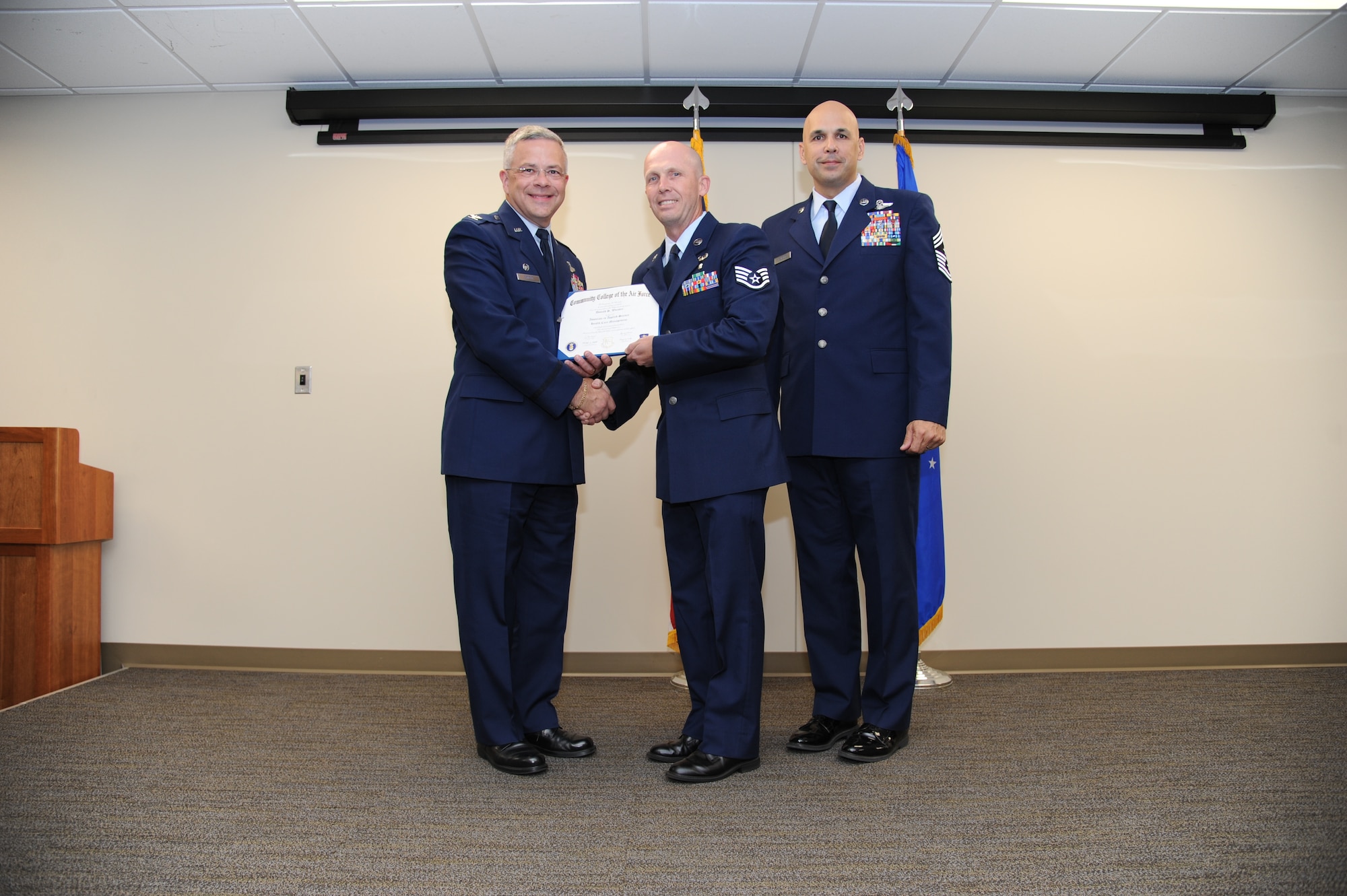 Col. Randal Bright, commander of the 927th Air Refueling Wing, MacDill Air Force Base, Fla., and Chief Master Sgt. Michael Klausutis, 927 ARW command chief present Staff Sgt. Donald S. Worster his Community College of the Air Force diploma during a ceremony held here May 3, 2015. (U.S. Air Force photo/Tech. Sgt. Peter Dean)