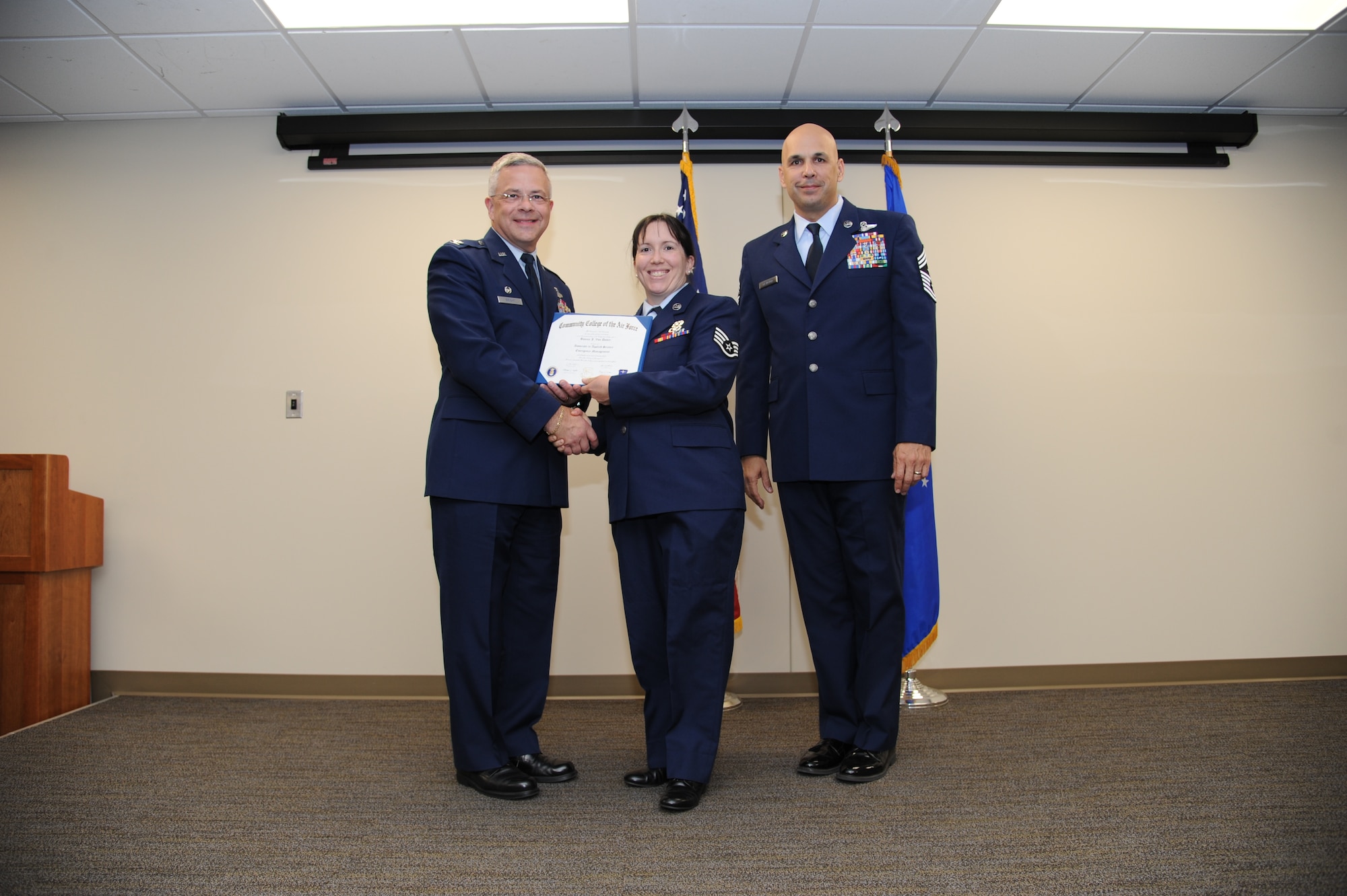 Col. Randal Bright, commander of the 927th Air Refueling Wing, MacDill Air Force Base, Fla., and Chief Master Sgt. Michael Klausutis, 927 ARW command chief present Staff Sgt. Bonnie J. Von Dohre her Community College of the Air Force diploma during a ceremony held here May 3, 2015.(U.S. Air Force photo/Tech. Sgt. Peter Dean)