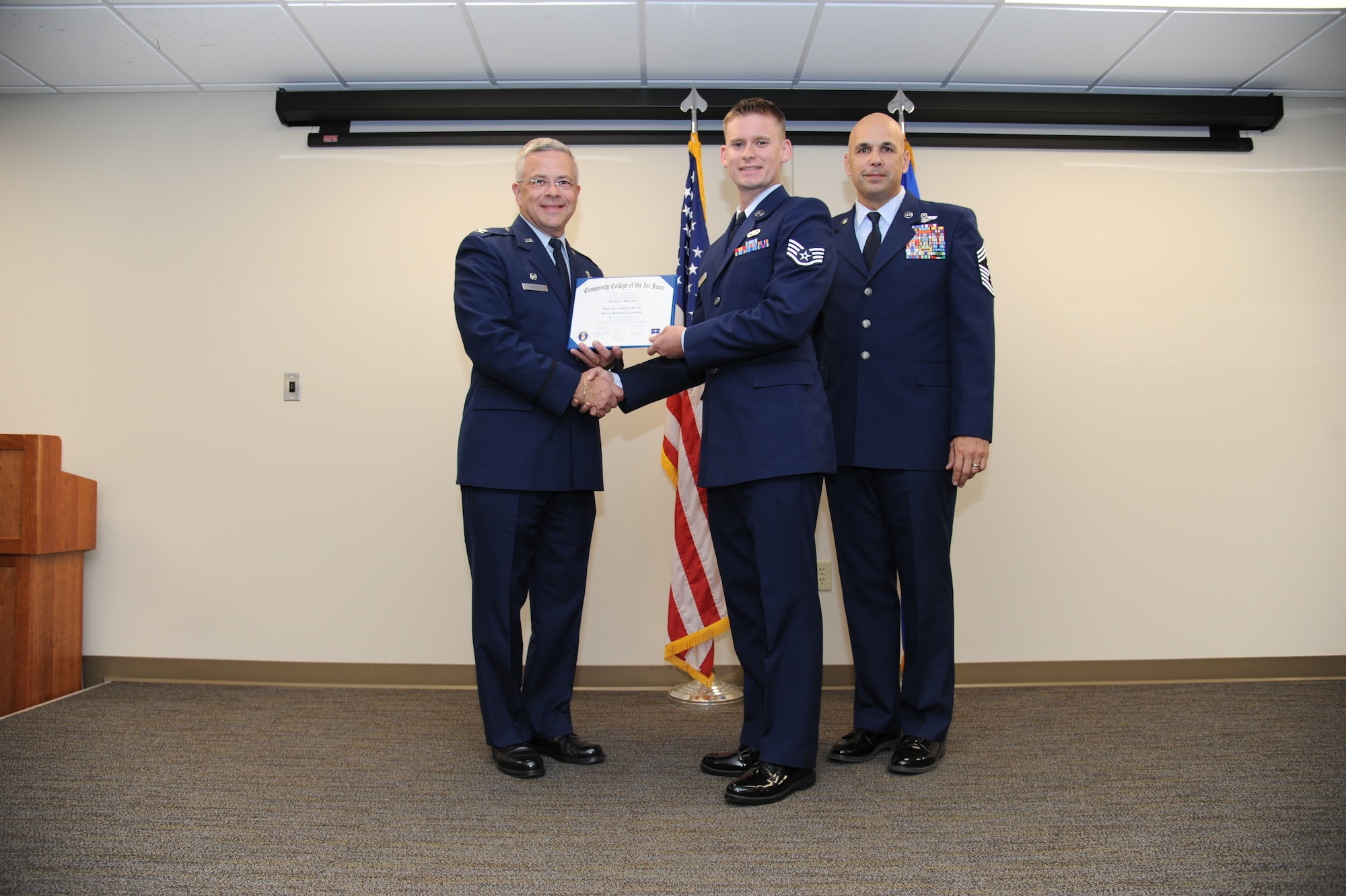 Col. Randal Bright, commander of the 927th Air Refueling Wing, MacDill Air Force Base, Fla., and Chief Master Sgt. Michael Klausutis, 927 ARW command chief present Staff Sgt. Phillip L. Sheridan his Community College of the Air Force diploma during a ceremony held here May 3, 2015. (U.S. Air Force photo/Tech. Sgt. Peter Dean)