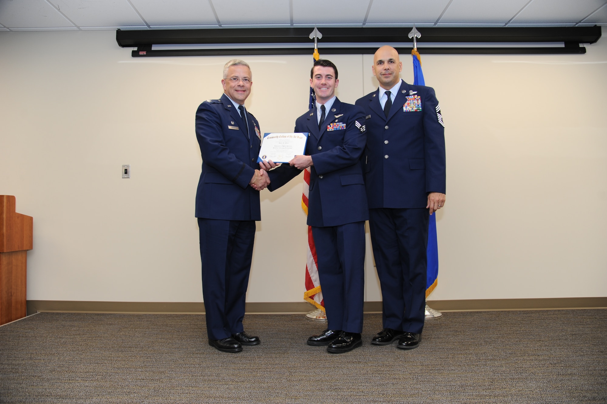 Col. Randal Bright, commander of the 927th Air Refueling Wing, MacDill Air Force Base, Fla., and Chief Master Sgt. Michael Klausutis, 927 ARW command chief present Senior Airman Jamie D. Price his Community College of the Air Force diploma during a ceremony held here May 3, 2015.(U.S. Air Force photo/Tech. Sgt. Peter Dean)