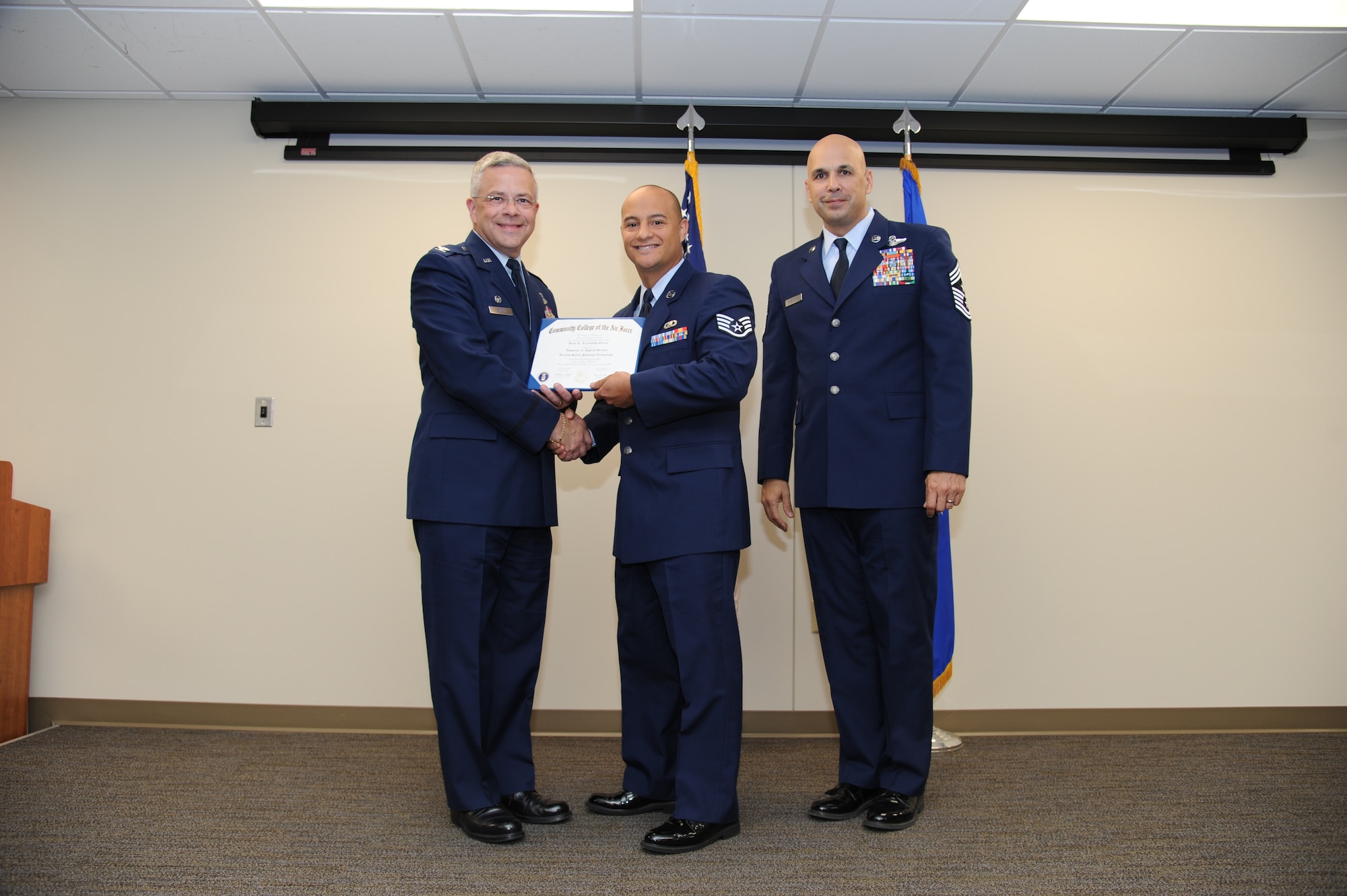 Col. Randal Bright, commander of the 927th Air Refueling Wing, MacDill Air Force Base, Fla., and Chief Master Sgt. Michael Klausutis, 927 ARW command chief present Staff Sgt. Juan D. Larraondo-Garcia his Community College of the Air Force diploma during a ceremony held here May 3, 2015. (U.S. Air Force photo/Tech. Sgt. Peter Dean)