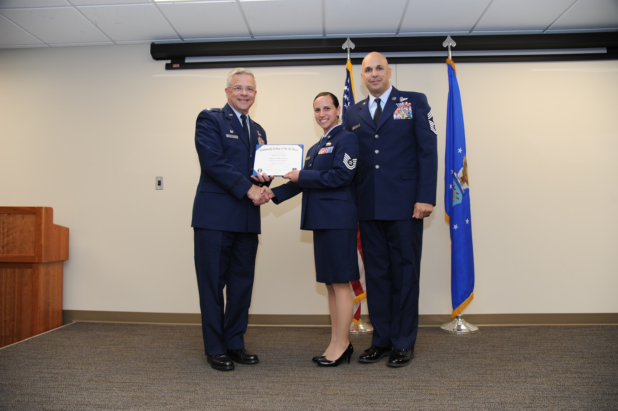 Col. Randal Bright, commander of the 927th Air Refueling Wing, MacDill Air Force Base, Fla., and Chief Master Sgt. Michael Klausutis, 927 ARW command chief present Tech. Sgt. Shannon M. Crosby her Community College of the Air Force diploma during a ceremony held here May 3, 2015.. (U.S. Air Force photo/Tech. Sgt. Peter Dean)
