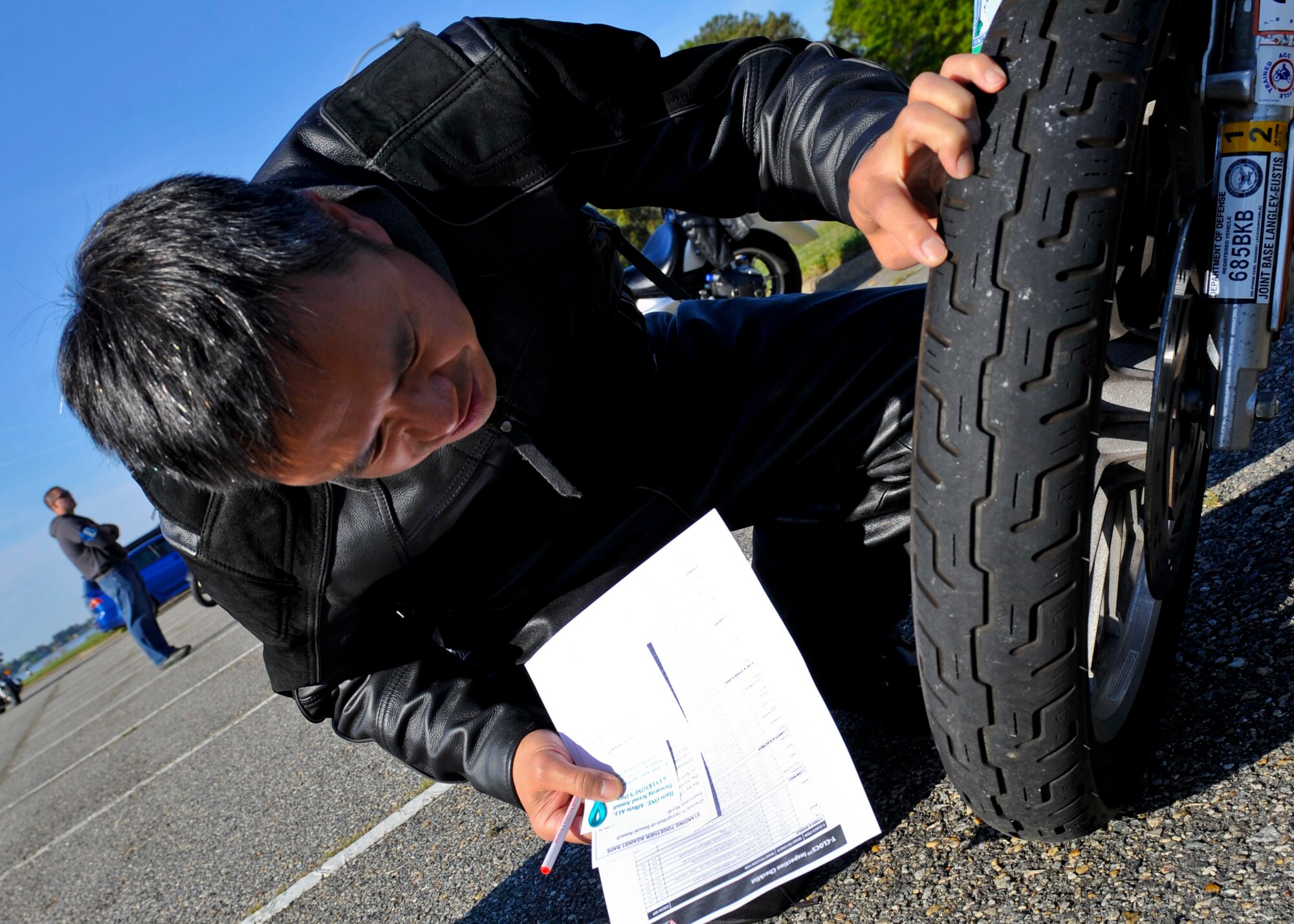 David Kwong, Air Combat Command A6 information technology specialist, performs a safety check on his motorcycle during the 4th Annual Standing Together Against Rape Road Rally at Langley Air Force Base, Va., April 29, 2015. Motorcyclists were given a safety brief and performed a safety check on their motorcycles prior to their ride to Surry, Va.(U.S. Air Force photo by Senior Airman Breonna Veal/Released)