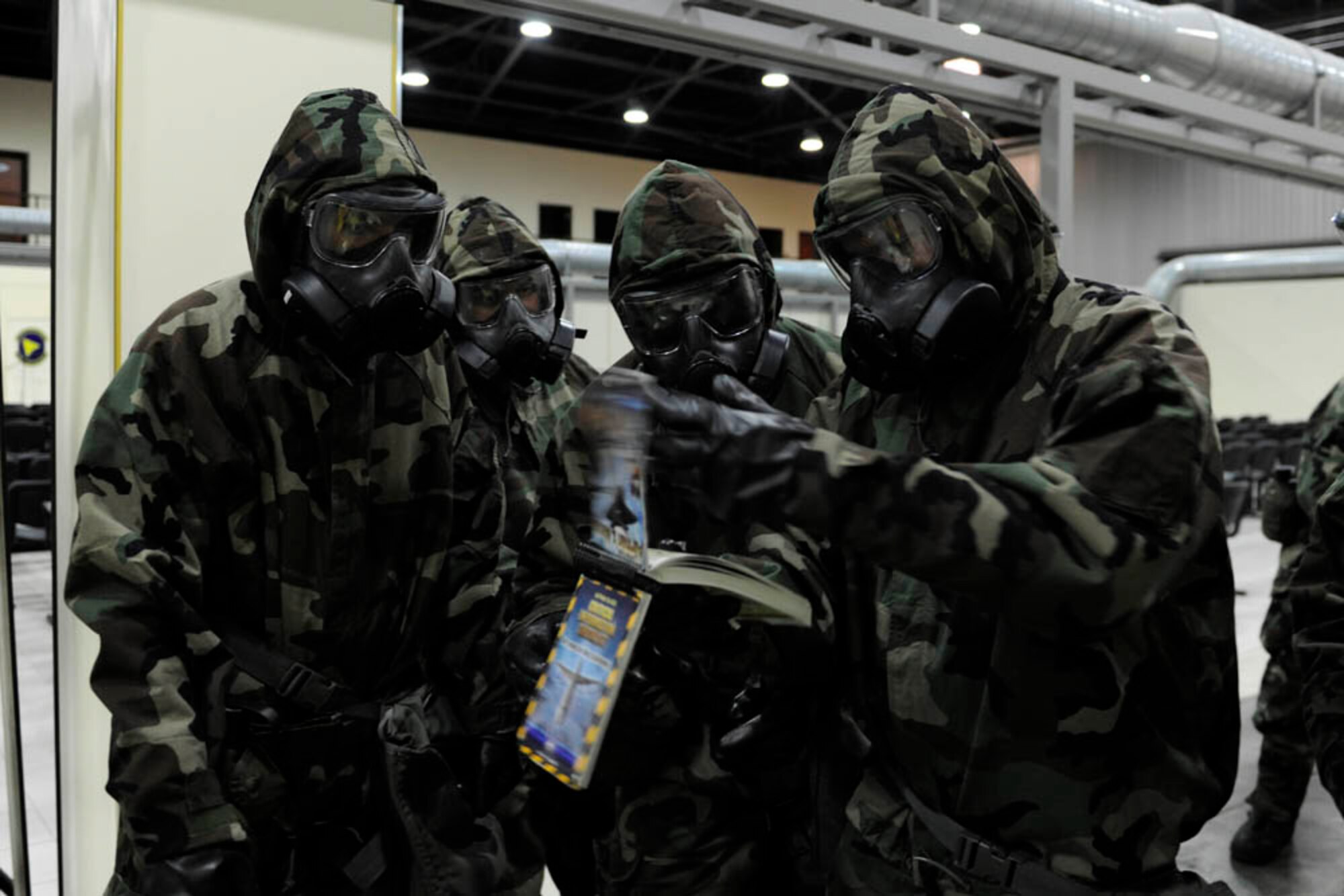 Airmen from the 39th Air Base Wing and 39th Comptroller Squadron consult an Airman's Manual during a base wide exercise April 29, 2015, at Incirlik Air Base, Turkey. The Airmen utilized their manuals to research the proper way to mark a contaminated vehicle. (U.S. Air Force photo by Senior Airman Krystal Ardrey/Released)