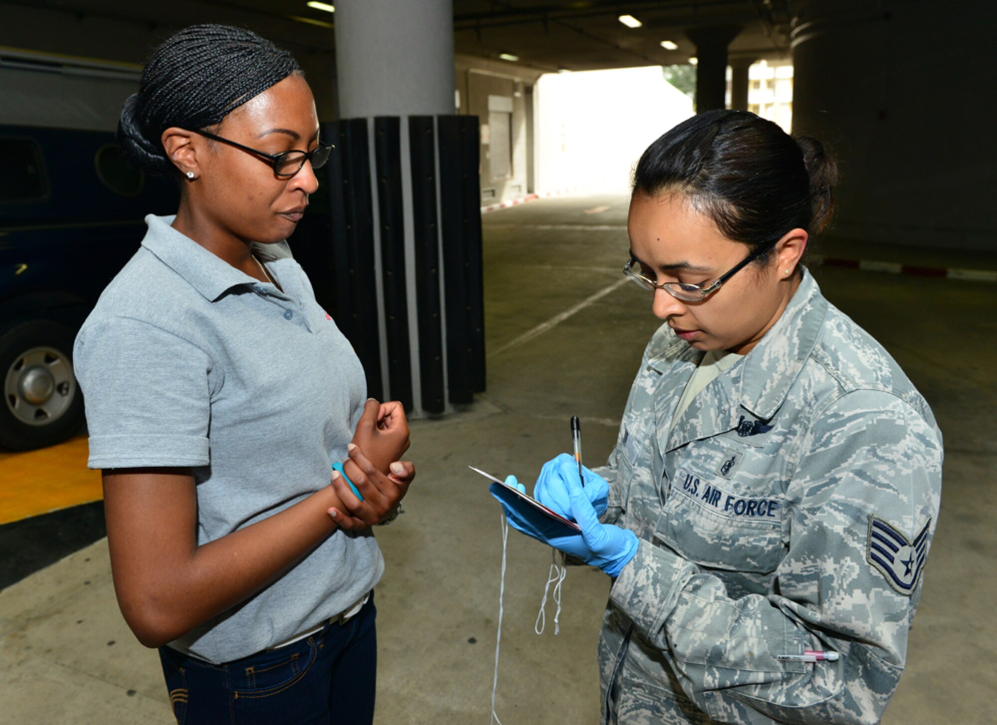 Staff Sgt. Maya Baker, 39th Medical Operations Squadron flight medicine technician, performs an injury assessment on Senior Airman Nia Curry, 39th Medical Operations Squadron bioenvironmental engineering technician, during a base-wide exercise April 29, 2015, at Incirlik Air Base, Turkey. During the exercise members from the 39th Medical Group were tested on their ability to rapidly attend to the injured victims. (U.S. Air Force photo by Senior Airman Michael Battles/Released)
