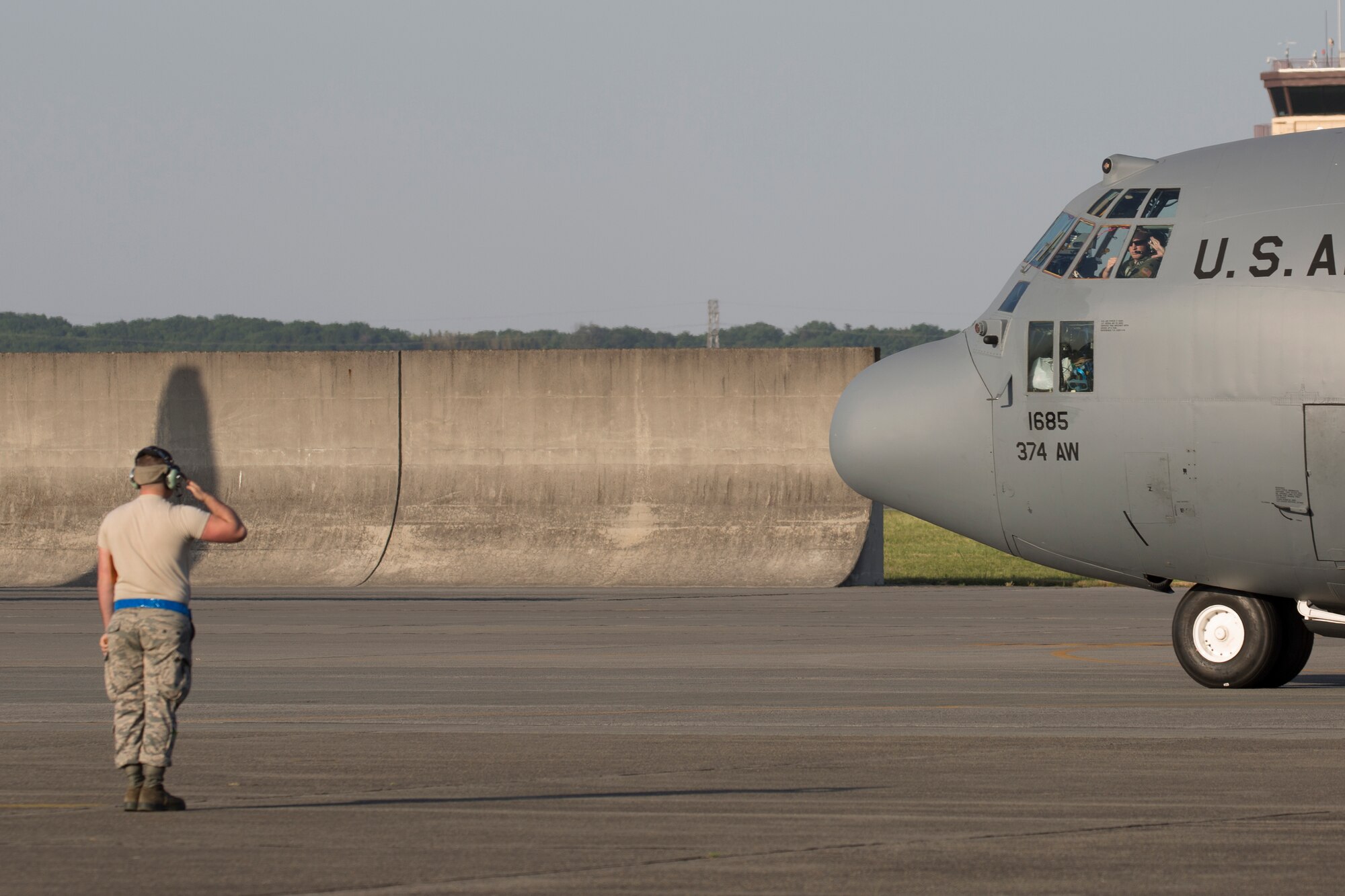A crew chief with the 374th Aircraft Maintenance Squadron salutes aircrew members as they taxi to leave Yokota Air Base, Japan, in support of the U.S. Agency of International Development and the Government of Nepal, May 5, 2015. Airmen departed to conduct humanitarian assistance and disaster relief operations in support of the Government of Nepal in the wake of a 7.8 magnitude earthquake that devastated many regions of the country on April 25, 2015. (U.S. Air Force photo by Osakabe Yasuo/Released) 