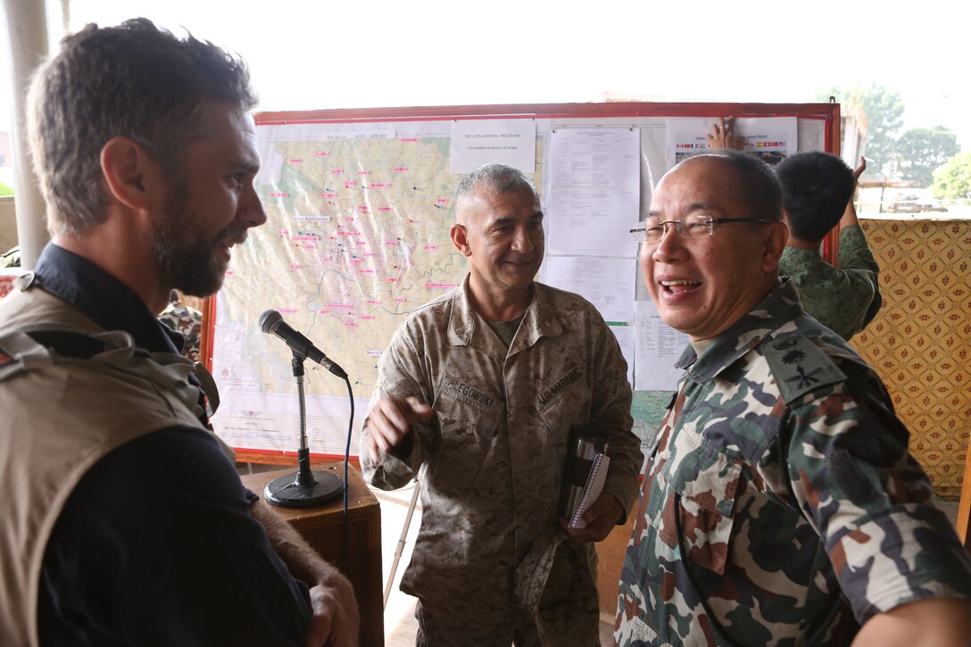 From left to right: Scott Aronson of USAID, Marine Lt. Col. Rod Legowski of 3rd Marine Expeditionary Brigade, and Nepalese army Col. Naresh Subba enjoy conversation after the Multi-National Military Coordination Center's morning briefing in Kathmandu, Nepal, May 5, 2015. 