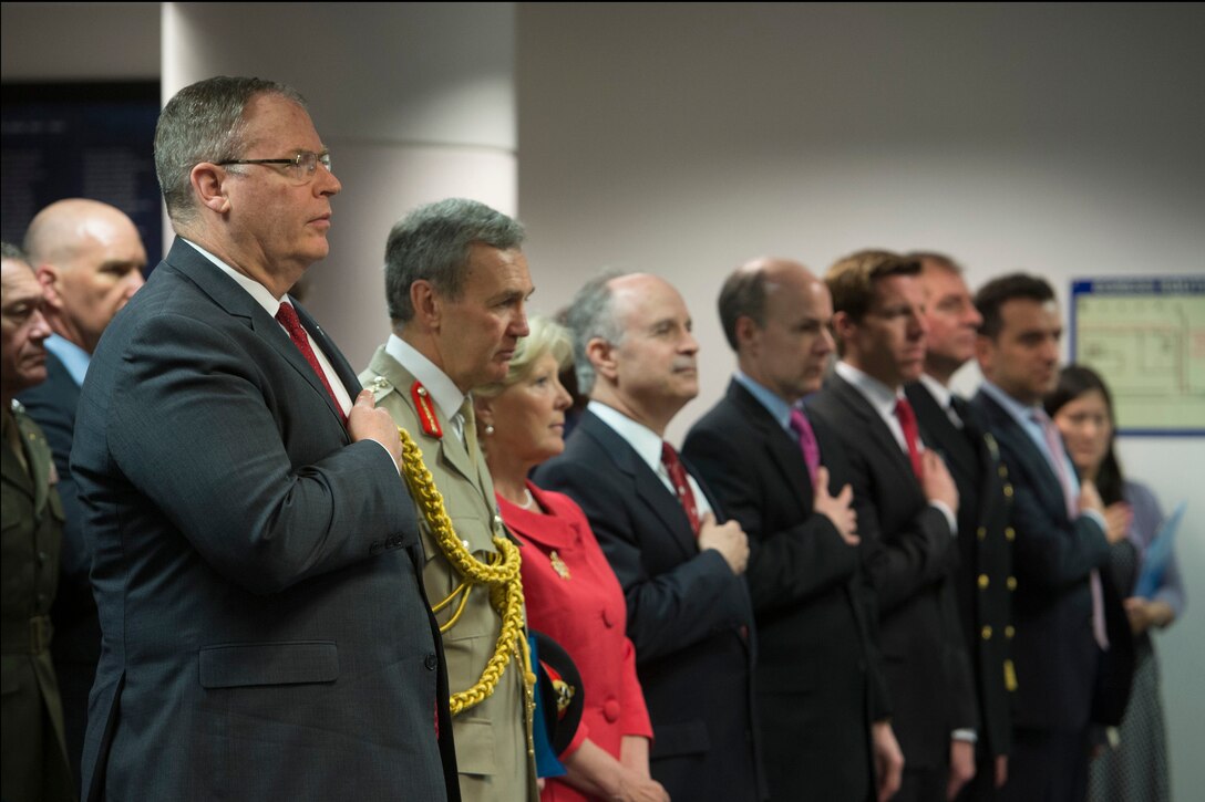 U.S. Deputy Defense Secretary Bob Work, foreground left, places his hand over his heart during the playing of the national anthem at a ceremony for the presentation of a bust of Sir Winston Churchill at the Pentagon, May 6, 2015. The United Kingdom defense ministry presented the bust to the Defense Department.
