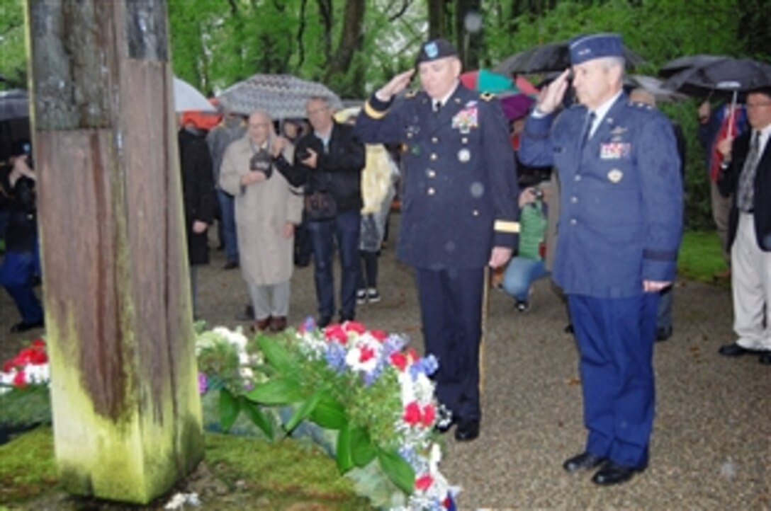 U.S. Army Maj. Gen. Robbie L. Asher, the adjutant general of Oklahoma; and U.S. Air Force Maj. Gen. H. Michael Edwards, the adjutant general of Colorado; salute after laying a wreath during a ceremony to honor the several thousand prisoners of Dachau concentration camp who were buried in Leitenberg Cemetery in Munich, Germany, May 1, 2015.