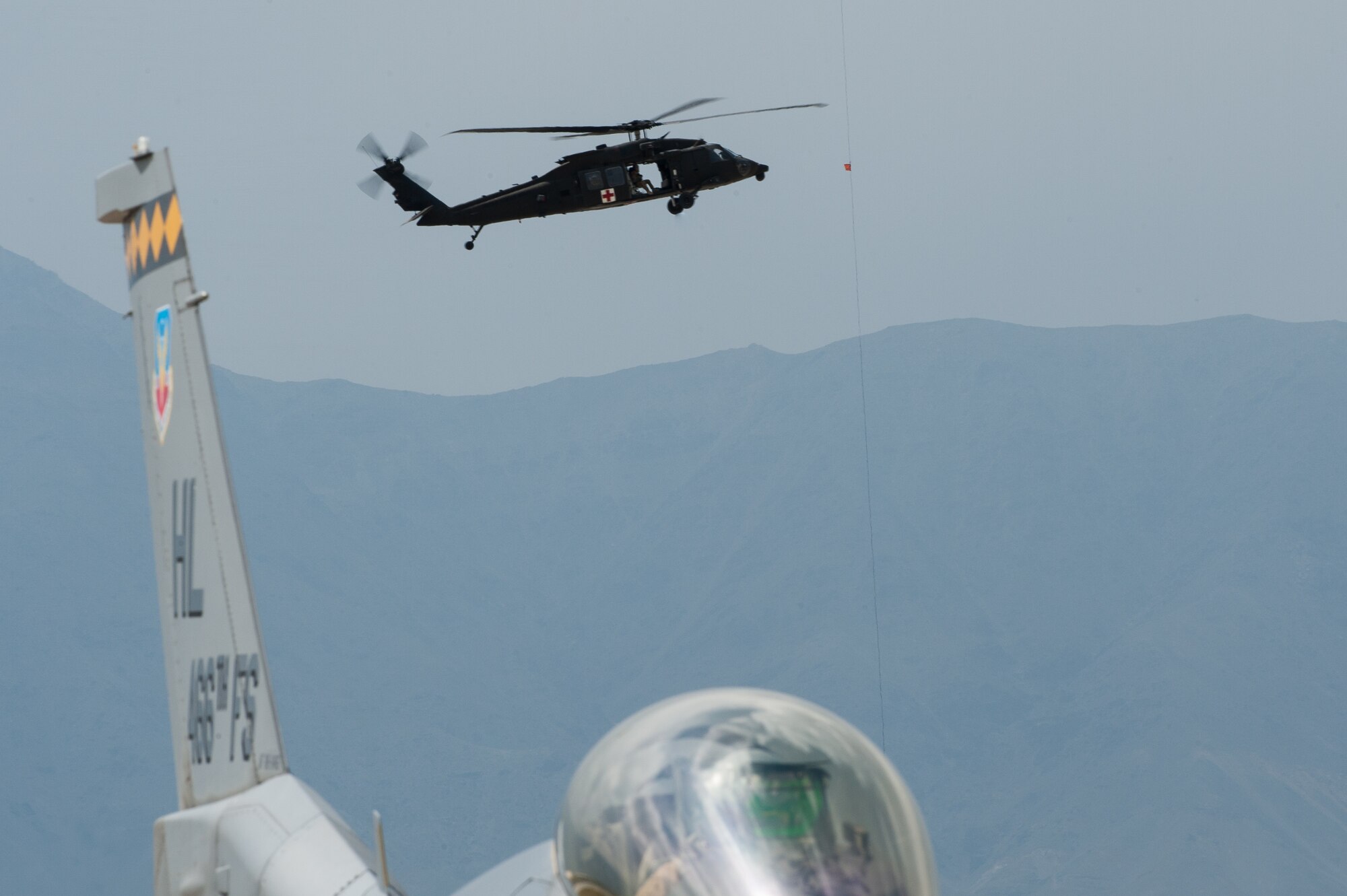 U.S. Air Force Capt. Derek Kirkwood, an F-16 Fighting Falcon pilot, assigned to the 4th Fighter Squadron from Hill Air Force Base, Utah, prepares for takeoff from Bagram Airfield, Afghanistan as a medical evacuation Blackhawk helicopter flies in the background, April 30, 2015. The “Fuujins” of the 4th FS provided decisive airpower to ground commanders in Afghanistan throughout their six month deployment, flying more than 8,000 hours in the F-16 in support of operations Enduring Freedom and Freedom’s Sentinel.  (U.S. Air Force photo by Tech Sgt. Joseph Swafford/Released)