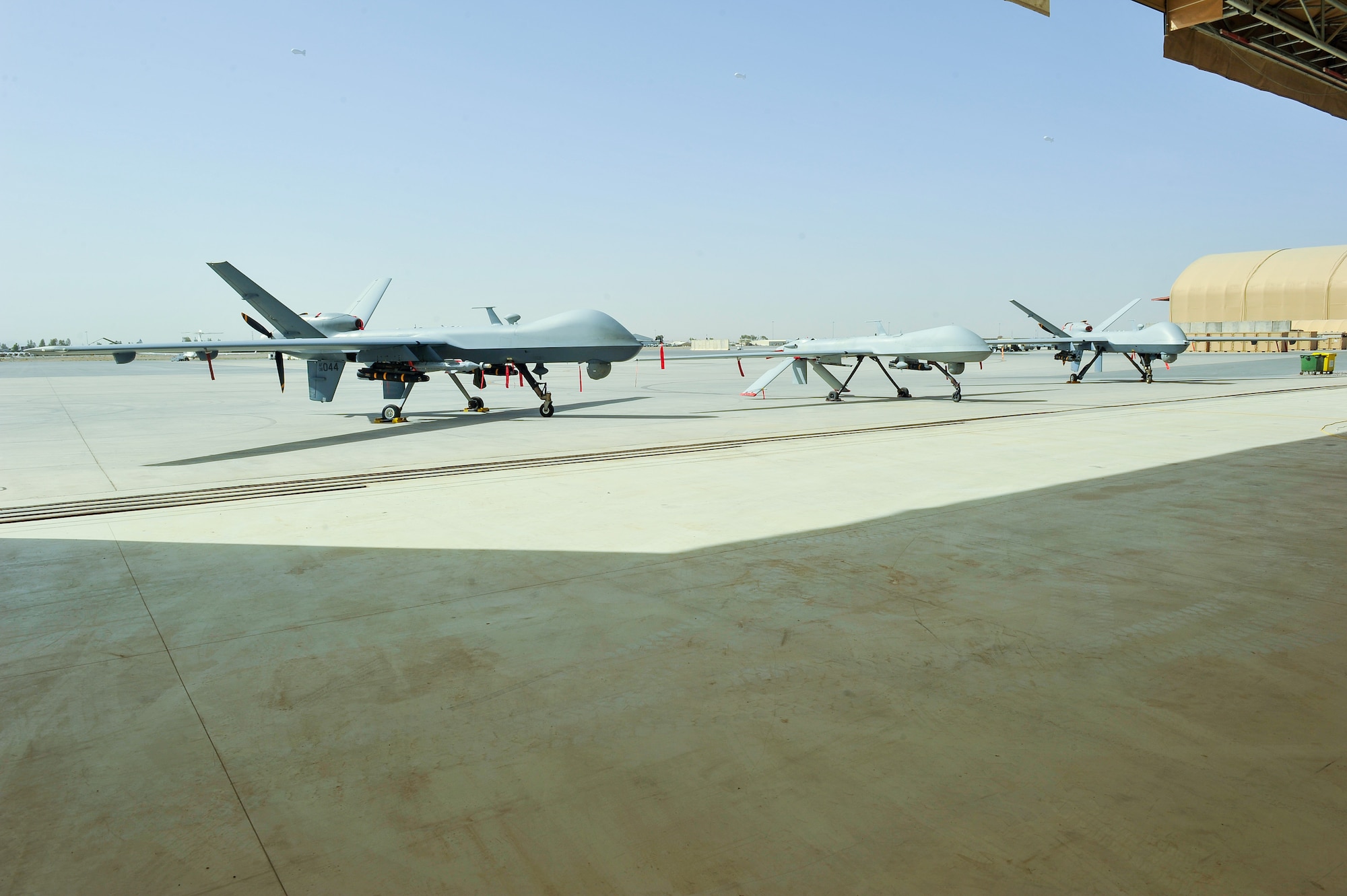 MQ-9 Reapers and MQ-1 Predator aircraft assigned to the 451st Air Expeditionary Group sit on static display at Kandahar Air Field, May 3, 2015. An MQ-9, like the ones shown, suffered damage during a non-combat related hard landing, but Airmen from the 451st AEG safety office and 451st Expeditionary Aircraft Maintenance Squadron worked together to get the aircraft back into the line to support the air tasking order after only a week.  (U.S. Air Force photo by Maj. Tony Wickman/Released)