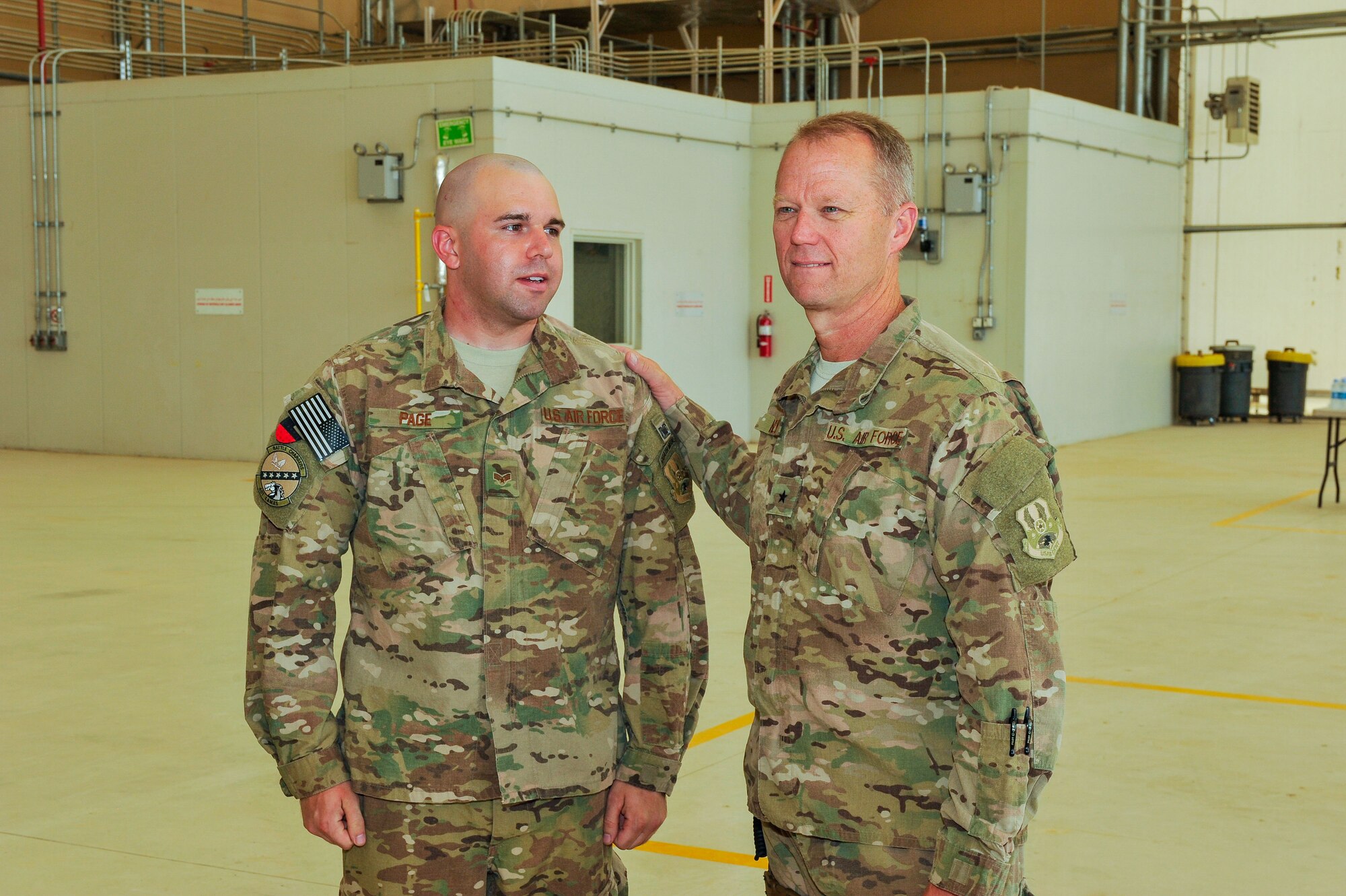U.S. Air Force Brig. Gen. Mark D. Kelly, 455th Expeditionary Wing commander, speaks with Staff Sgt. Courtlyn Collier, 451st Expeditionary Aircraft Maintenance Squadron crew chief, about the innovative hard work he accomplished in repairing a MQ-9 Reaper aircraft at Kandahar Airfield, Afghanistan, May 3, 2015.  Airmen from the 451st Air Expeditionary Group safety office and 451st EAMXS worked together to get the aircraft back into the line to support the air tasking order.  (U.S. Air Force photo by Maj. Tony Wickman/Released)