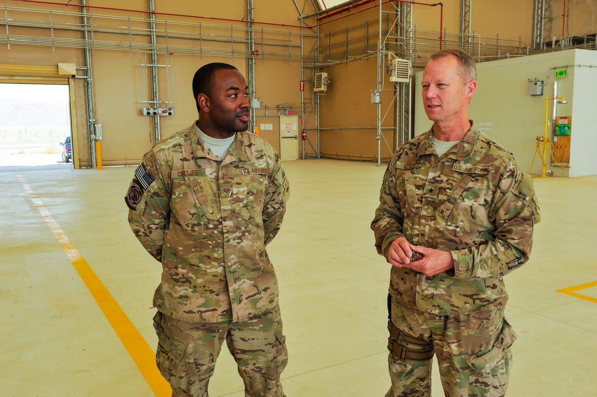 U.S. Air Force Brig. Gen. Mark D. Kelly, 455th Expeditionary Wing commander, speaks with Staff Sgt. Courtlyn Collier, 451st Expeditionary Aircraft Maintenance Squadron crew chief, about the innovative hard work he accomplished in repairing a MQ-9 Reaper aircraft at Kandahar Airfield, Afghanistan, May 3, 2015.  Airmen from the 451st Air Expeditionary Group safety office and 451st EAMXS worked together to get the aircraft back into the line to support the air tasking order.  (U.S. Air Force photo by Maj. Tony Wickman/Released)
