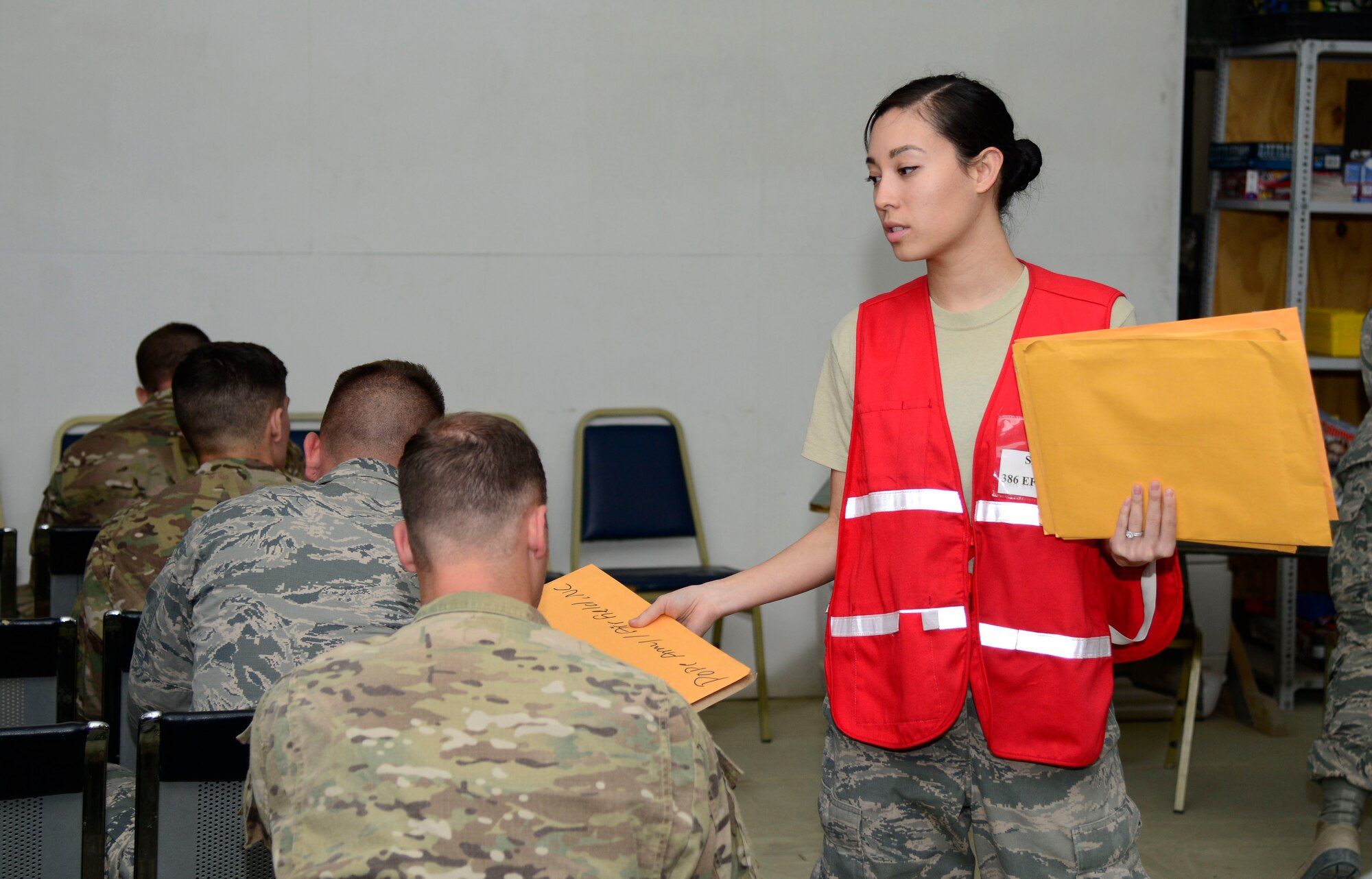 U.S. Air Force Senior Airman Laura Shabazz, a 386th Expeditionary Force Support Squadron sustainment technician, collects paperwork during in-processing at an undisclosed location May 5, 2015. Personnel Support for Contingency Operations provided information about the local area and emergency management actions. (U.S Air Force photo by Senior Airman Racheal E. Watson/Released)