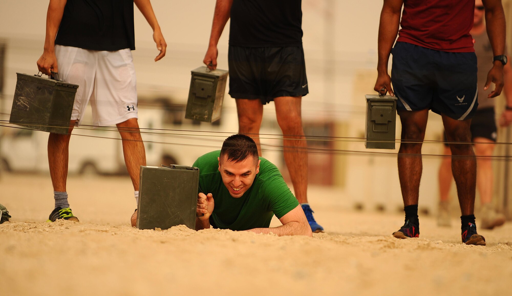 U.S. Airmen with the 386th Air Expeditionary Wing participate in the low crawl portion of an Explosive Ordnance Disposal Memorial Challenge in Southwest Asia, May 2, 2015. National EOD Day is a U.S. observance held the first Saturday in May, recognizing professionals who risked their lives disposing of explosives. (U.S. Air Force photo/Tech. Sgt. Brittany E. Jones/Released) 