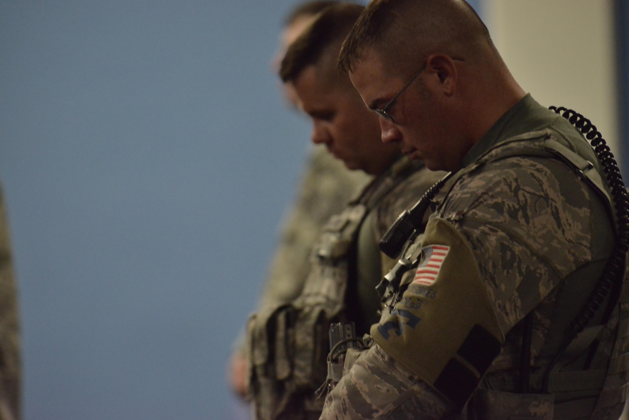 Members from the 379th Expeditionary Security Forces Squadron bow their heads as the Chaplin reads the invocation during a memorial service of MWD Jonny May 2, 2015 at the Blatchford-Preston Complex at Al Udeid Air Base, Qatar. ( U.S. Air Force photo by Staff Sgt. Alexandre Montes)