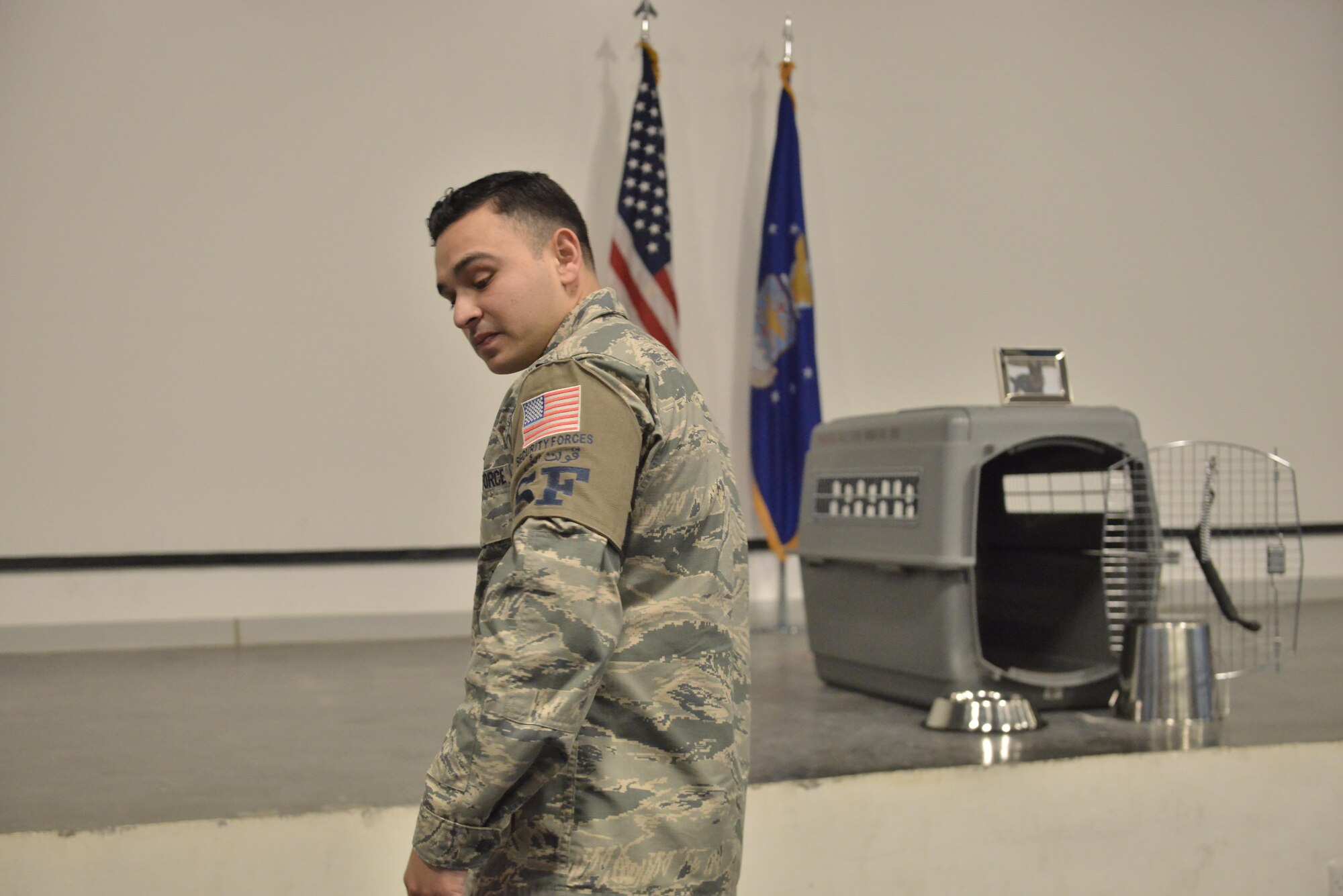 Senior Airman Jerry Quintanilla, 379th Expeditionary Security Forces Squadron exits the memorial service held in honor of Military Working Dog Jonny May 2, 2015 at the Blatchford-Preston Complex at Al Udeid Air Base, Qatar.  Jonny and Quintanilla worked side by side daily for three months before Jonny passed away due to medical complications. ( U.S. Air Force photo by Staff Sgt. Alexandre Montes)