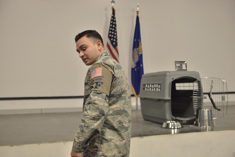 Senior Airman Jerry Quintanilla, 379th Expeditionary Security Forces Squadron exits the memorial service held in honor of Military Working Dog Jonny May 2, 2015 at the Blatchford-Preston Complex at Al Udeid Air Base, Qatar.  Jonny and Quintanilla worked side by side daily for three months before Jonny passed away due to medical complications. ( U.S. Air Force photo by Staff Sgt. Alexandre Montes)