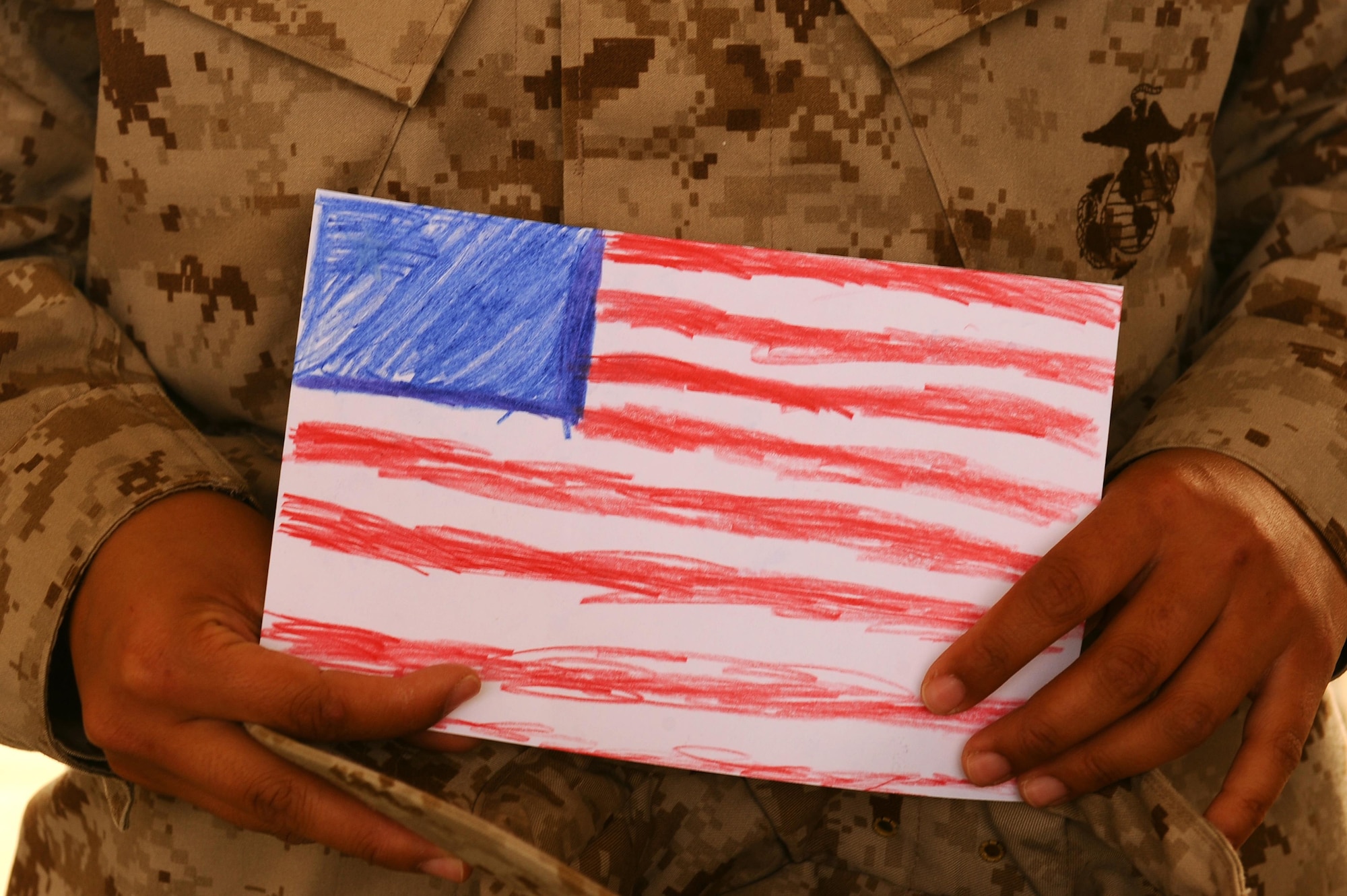 A U.S. Marine Corps member supporting the Special Purpose Marine Air Ground Task Force Crisis Response, Central Command, in Southwest Asia holds a piece of artwork, May 5, 2015. Rep. Susan Davis provided female Service members with t Mother’s Day cards created by elementary school students in California to honor all the women spending the holiday away from their children. (U.S. Air Force photo/Tech. Sgt. Brittany E. Jones/Released)