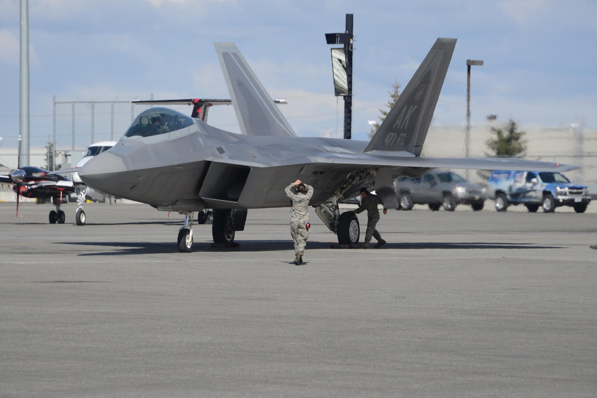 Airman 1st Class Heather Duffy, a Reserve Airman in the 477th Fighter Group, marshals Reserve F-22 pilot Maj. David Balmer into his parking location at the Alaska Aviation Gathering this past weekend. Members of the Air Force Reserve's 477th Fighter Group took the jet to be a part of the show that included more than 275 vendors and was attended by more than 23,000 visitors. (Air Force Photo/Tech. Sgt. Dana Rosso)

