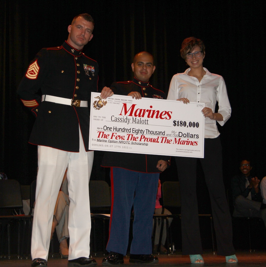 Gunnery Sgt. Gregory Hauk, the station commander for Recruiting Substation Orlando, and Sgt. Magno Choez, a canvassing recruiter for Recruiting Substation Orlando, present Cassidy Malott, a senior from Boone High School, Orlando Fl, with the NROTC Check.  Malott is part of a small percentage that receives the opportunity to become Marine Corps officers.