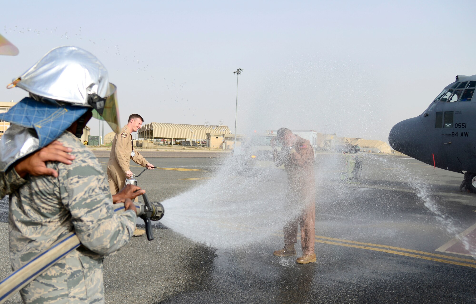U.S. Air Force Col. Joe Santos, the outgoing 386th Expeditionary Operations Group commander, is sprayed with a fire hose after his final flight at an undisclosed location in Southwest Asia May 6, 2015. Traditionally, wingmen of the departing crew meet the commander on the flight line to say farewell. (U.S. Air Force photo by Senior Airman Racheal E. Watson)