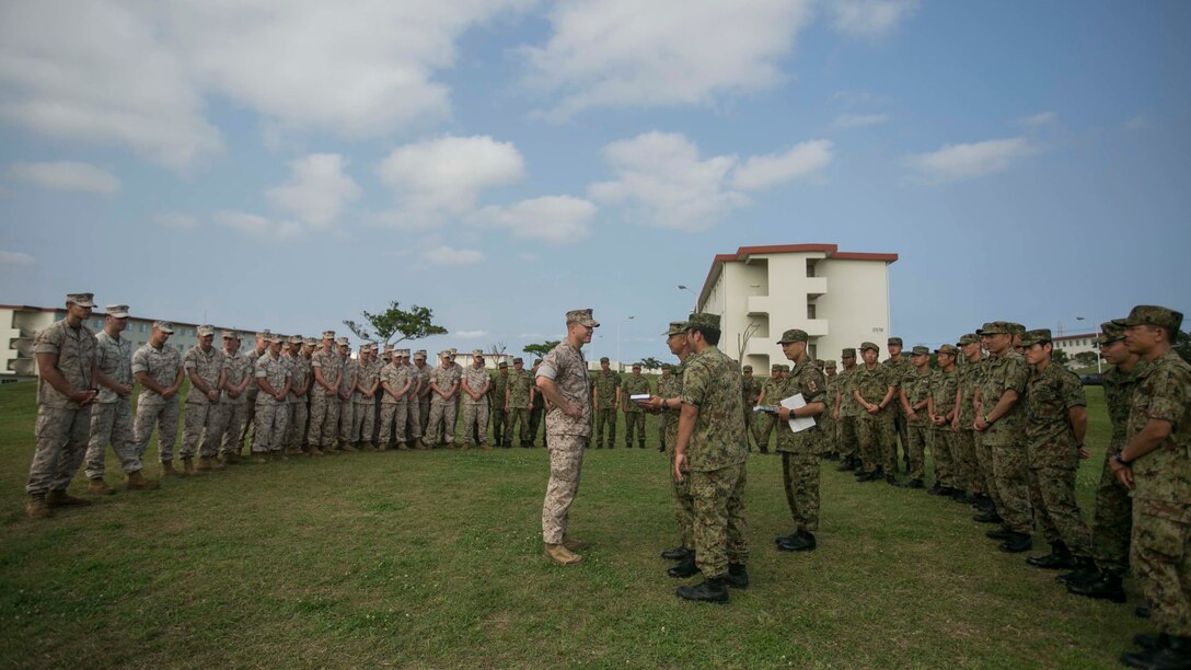 Japanese Ground Self-Defense Force soldiers and U.S. Marines come together for a gift exchange concluding the Japanese Observer Exchange Program April 30, 2015 at Camp Hansen. JOEP is a III Marine Expeditionary Force, 31st Marine Expeditionary Unit and JGSDF coordinated program designed to increase regional security, maintain unit readiness and enhance overall cooperation. This is the fourth iteration of JOEP for the 31st MEU after the initial partnership in September 2012. The Marines are with Battalion Landing Team 2nd Battalion, 4th Marines, 31st MEU. (U.S. Marine Corps photo by Lance Cpl. Tyler Ngiraswei/Released)