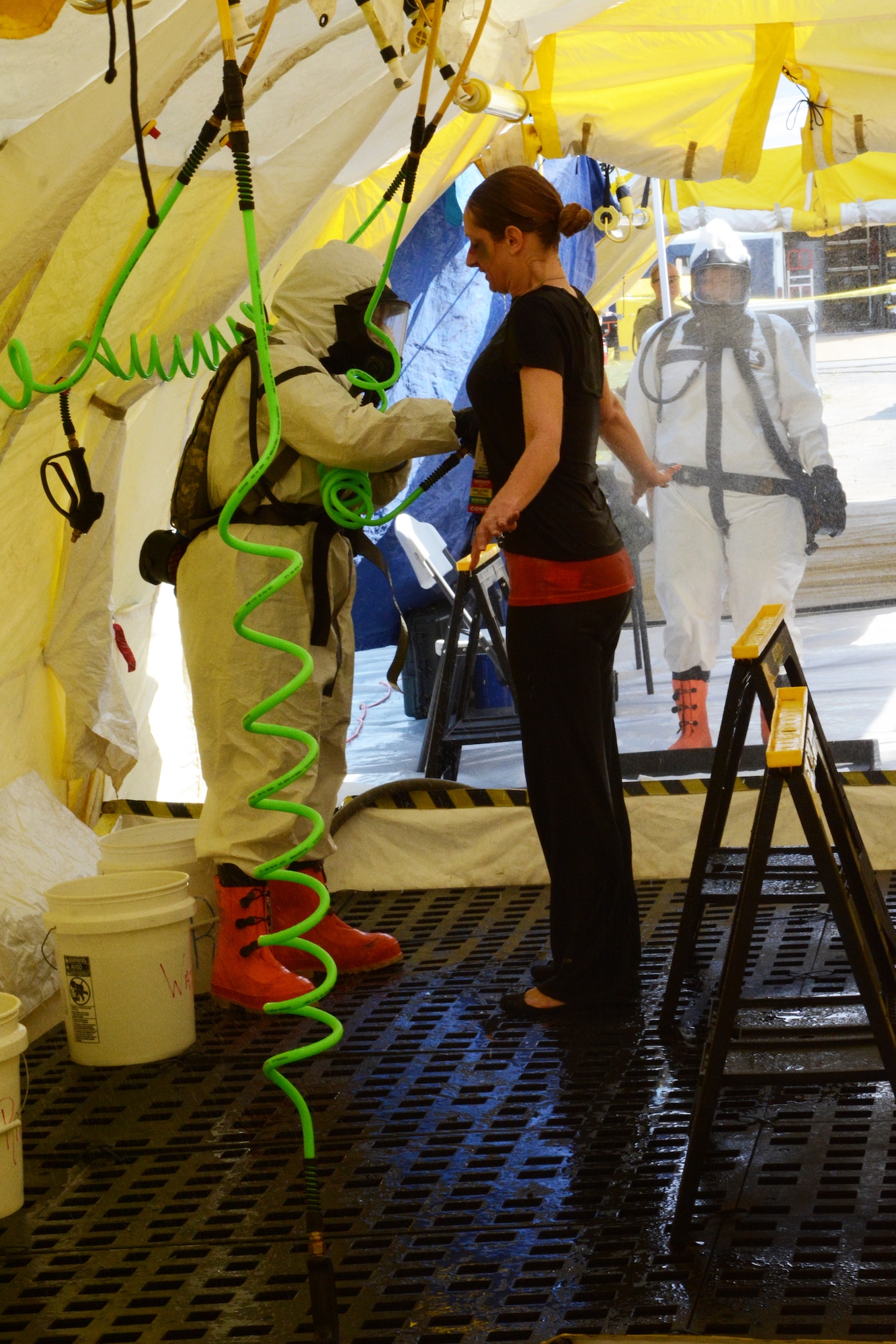 A Soldier in the Wisconsin National Guard sprays a woman from head-to-toe to ensure all chemicals are removed during a two-day Chemical, Biological, Radiological, Nuclear and Explosives Enhanced Response Force Package exercise at Volk Field Air National Guard Base, Wis., May 1-2. The exercise allowed service members to prepare for the first ever CERFP one-day inspection, scheduled to be held in June 2015. (U.S. Air National Guard photo by Senior Airman Andrea F. Rhode)