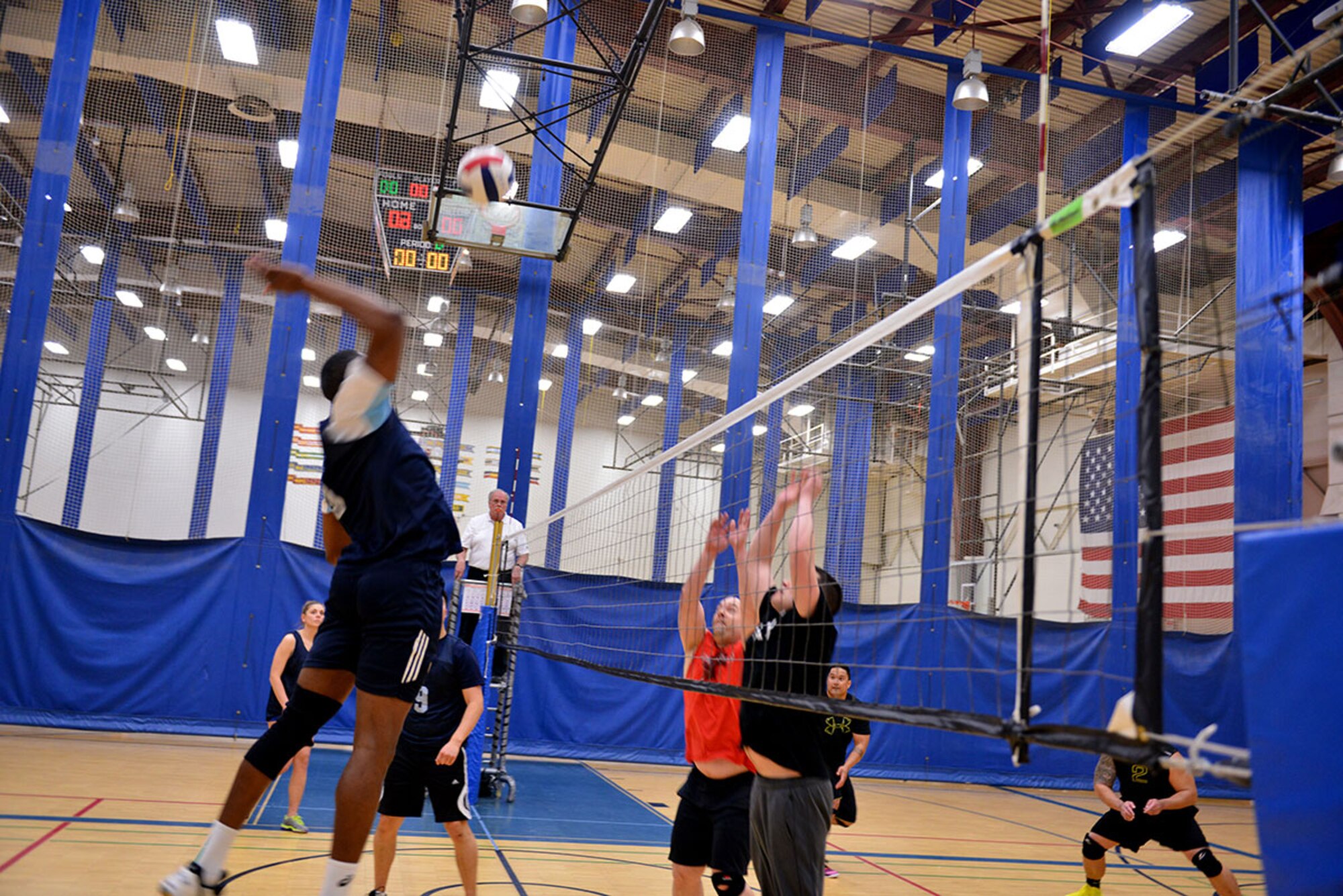 Specialist Tah Babila, a patient admininistrator at Medical and Dental Activity, Alaska, spikes the volleyball over the rising blocks of players from the opposing team at the intramural volleyball championship game April 30 at Buckner Physical Fitness Center. The Cincinnati, Ohio native played a pivotal role in securing victory, maintaining their undefeated record, and grabbing the trophy for his team. (U.S. Air Force photo/Airman 1st Class Kyle Johnson)